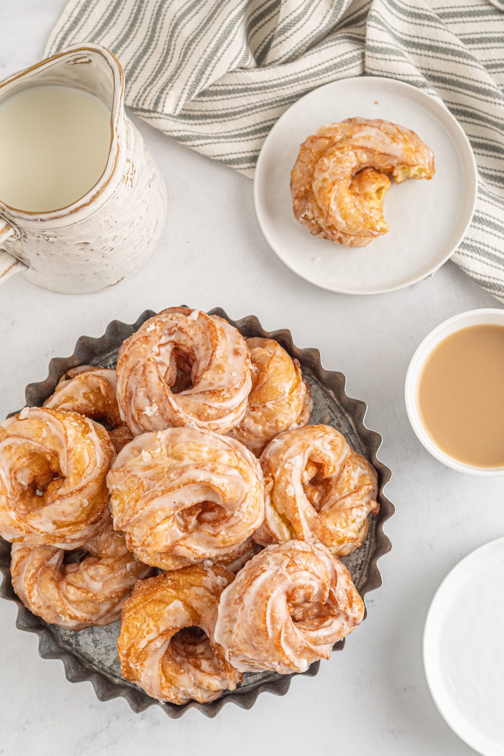 Overhead view of French Crullers stacked on a silver serving tray.