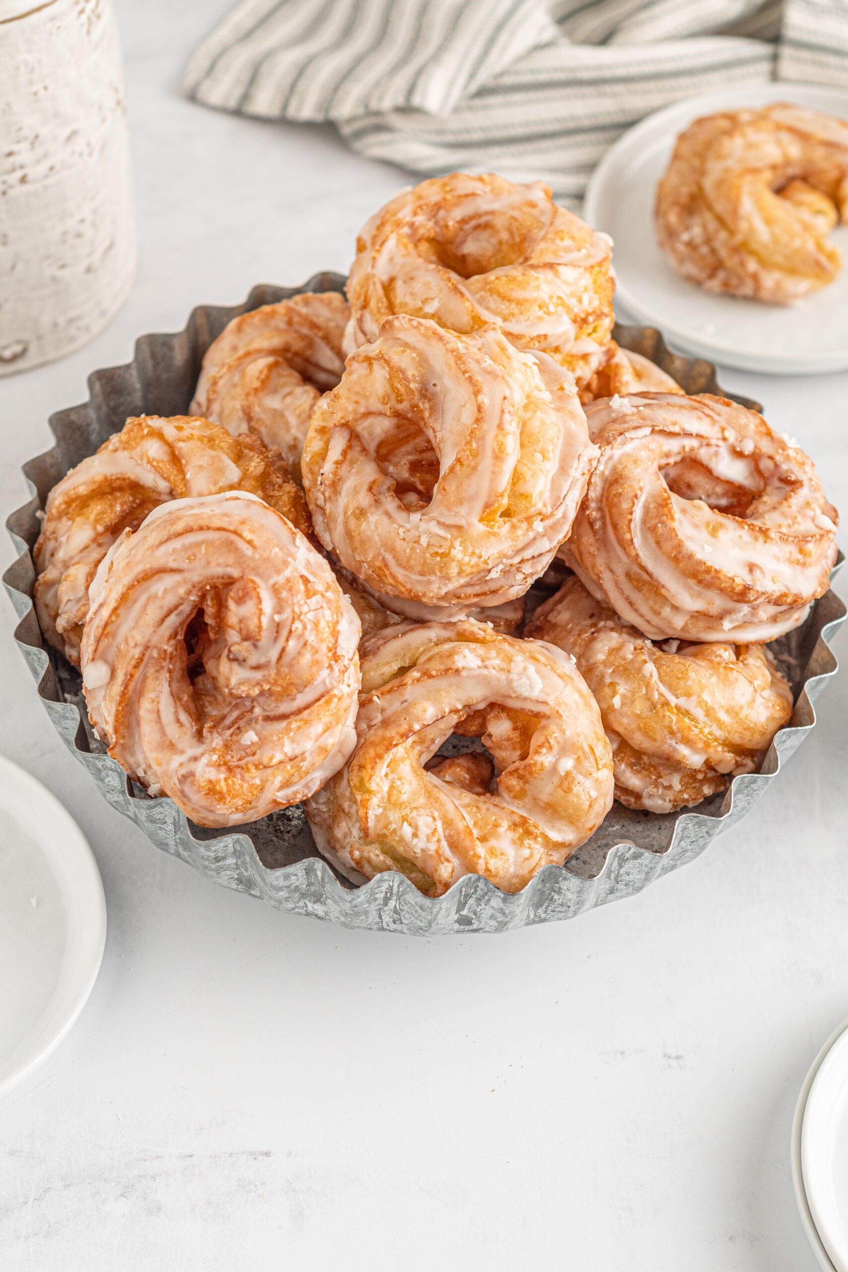 Overhead view of French Crullers stacked on a silver serving tray.