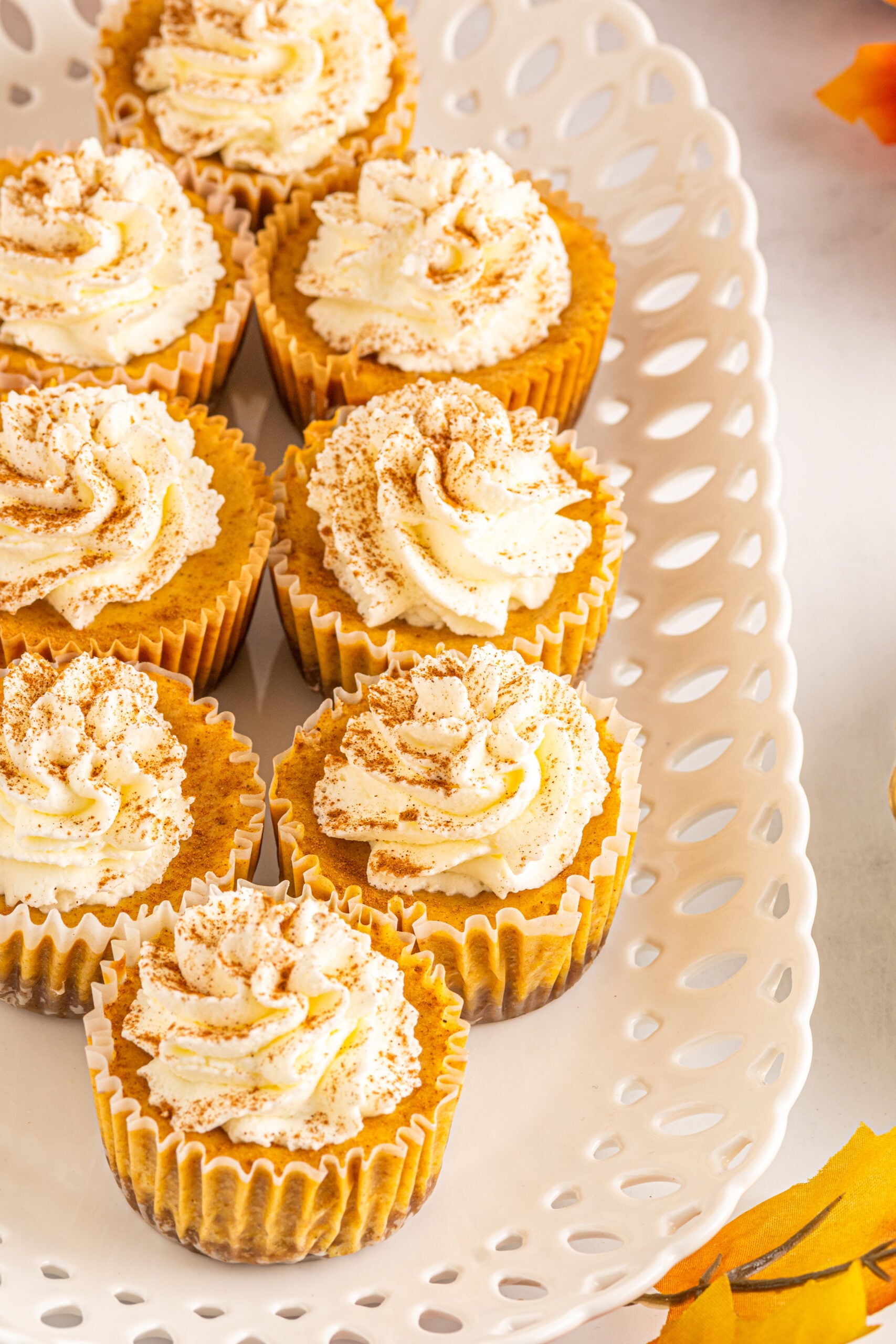 Front view of Mini Pumpkin Cheesecakes on a white serving dish.