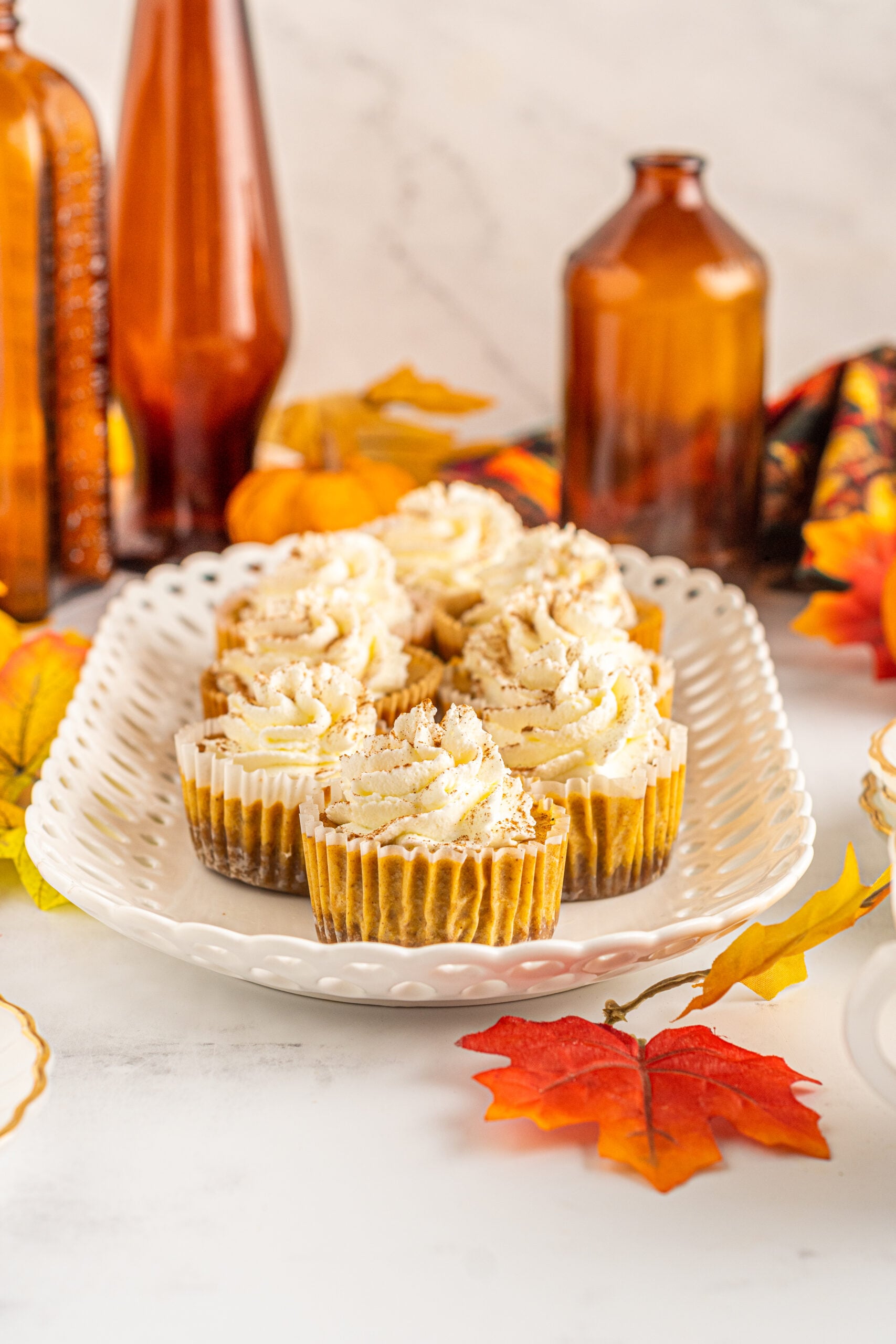 Front view of Mini Pumpkin Cheesecakes on a white serving dish.