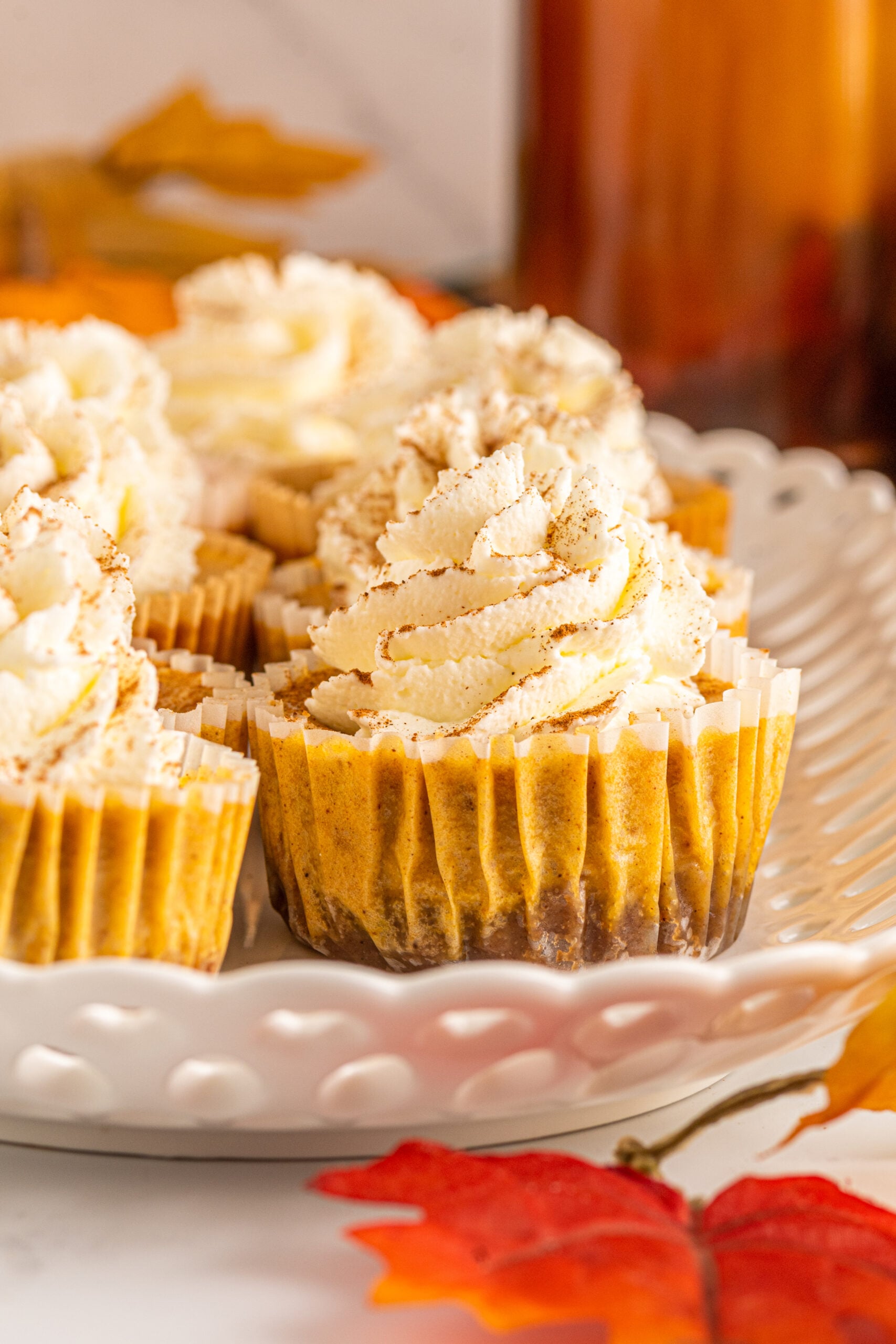 Close up view of Mini Pumpkin Cheesecakes on a white serving dish.