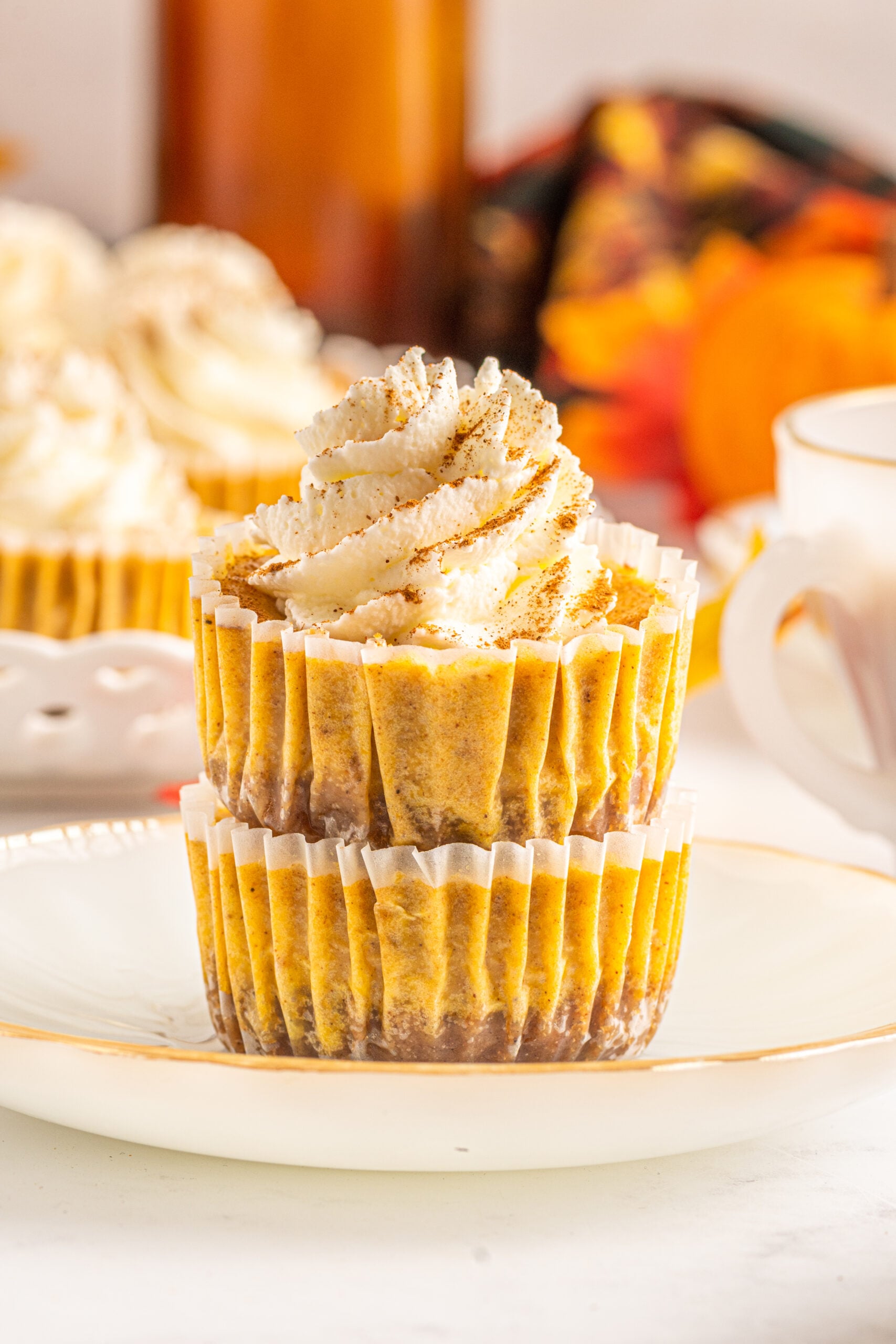 Front view of two Mini Pumpkin Cheesecakes stacked on a white dish.