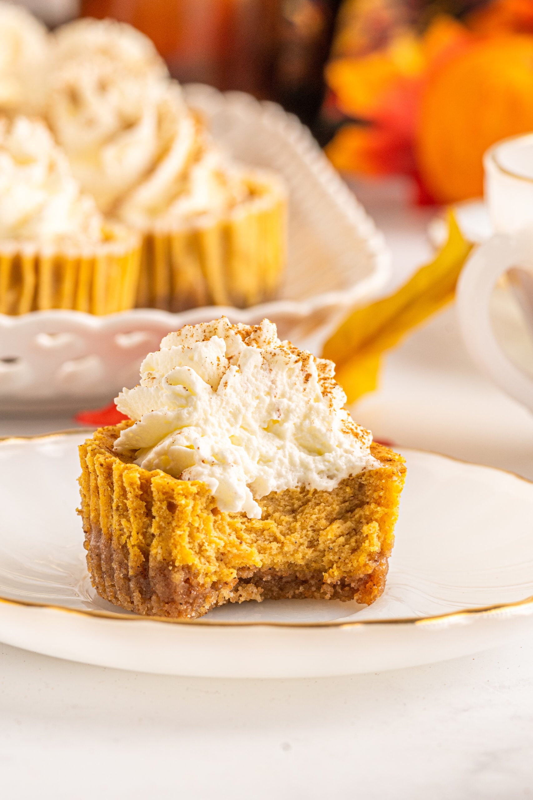 Front view of a Mini Pumpkin Cheesecake with a bite removed.