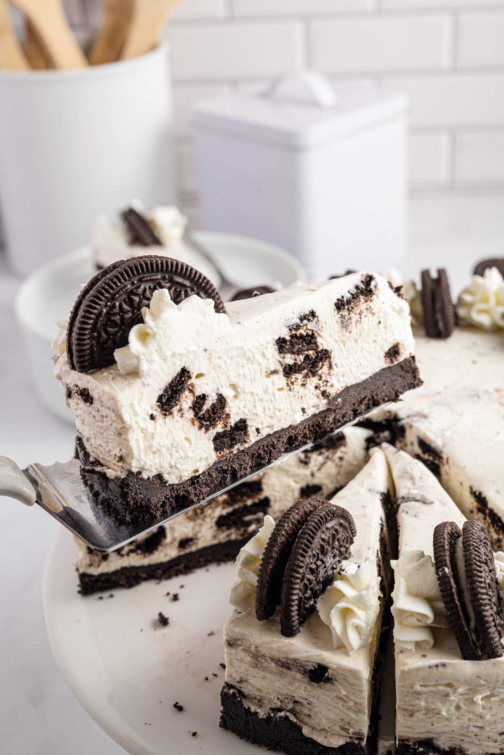 Side view of a slice of No Bake Oreo Cheesecake on a silver spatula.