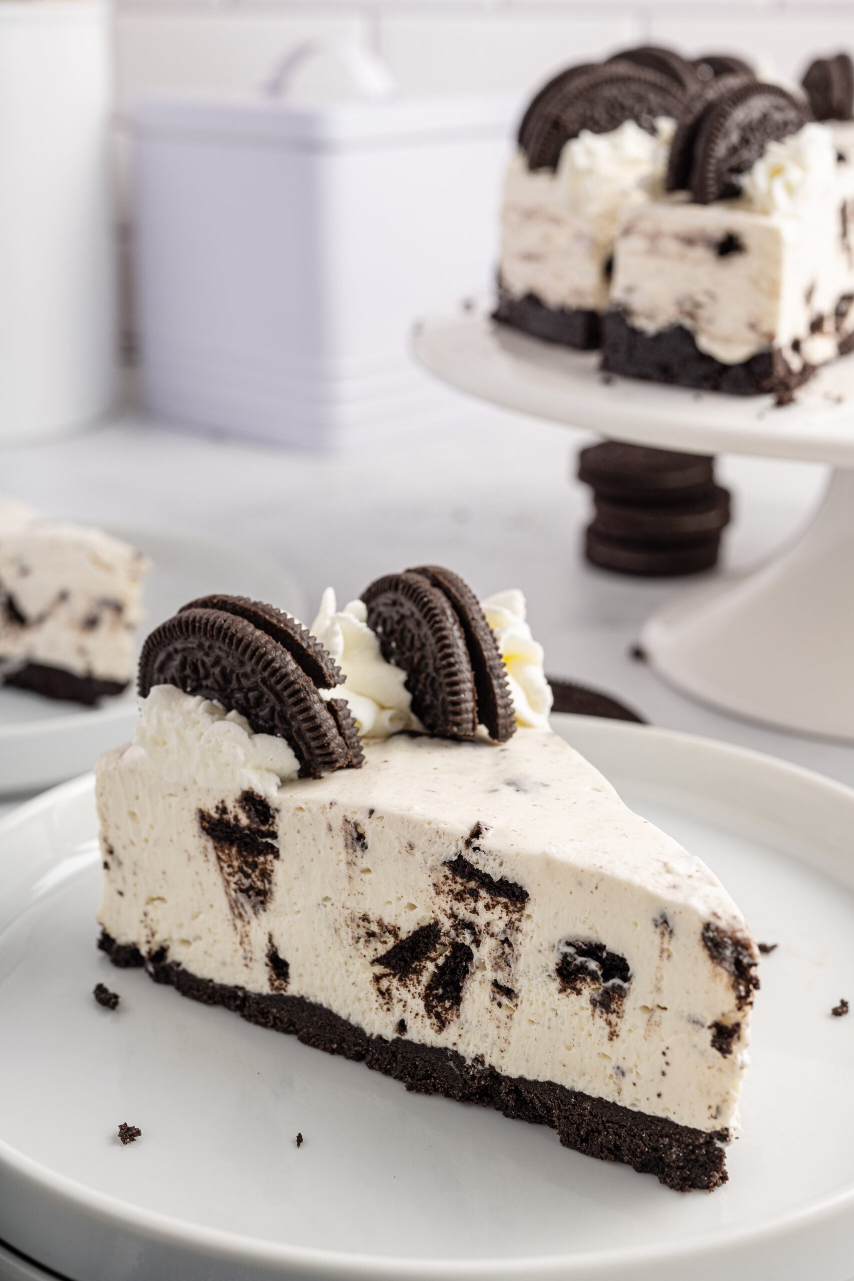 Side view of a slice of No Bake Oreo Cheesecake on a white dish.