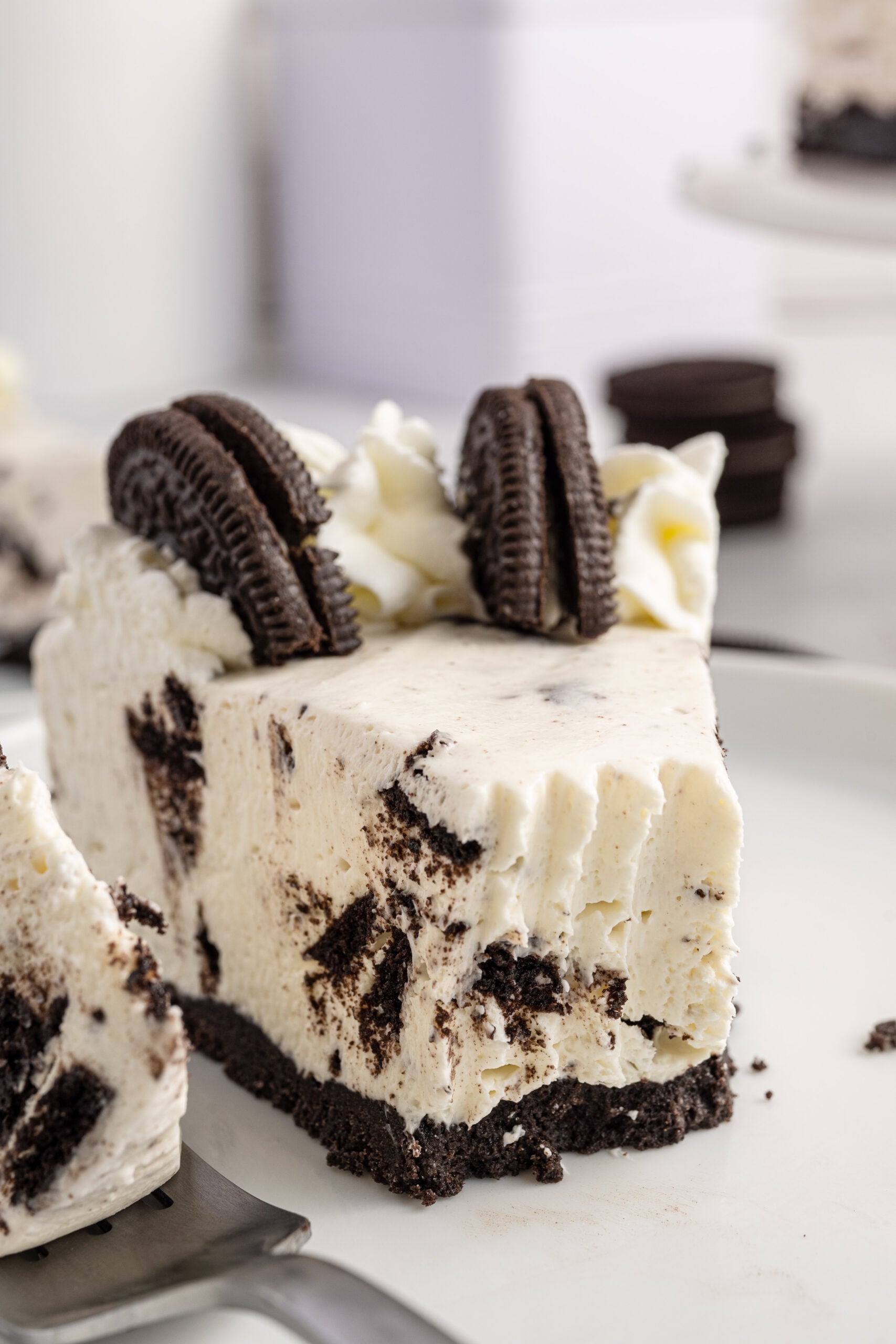 Up close view of No Bake Oreo Cheesecake with a piece removed with a silver fork.