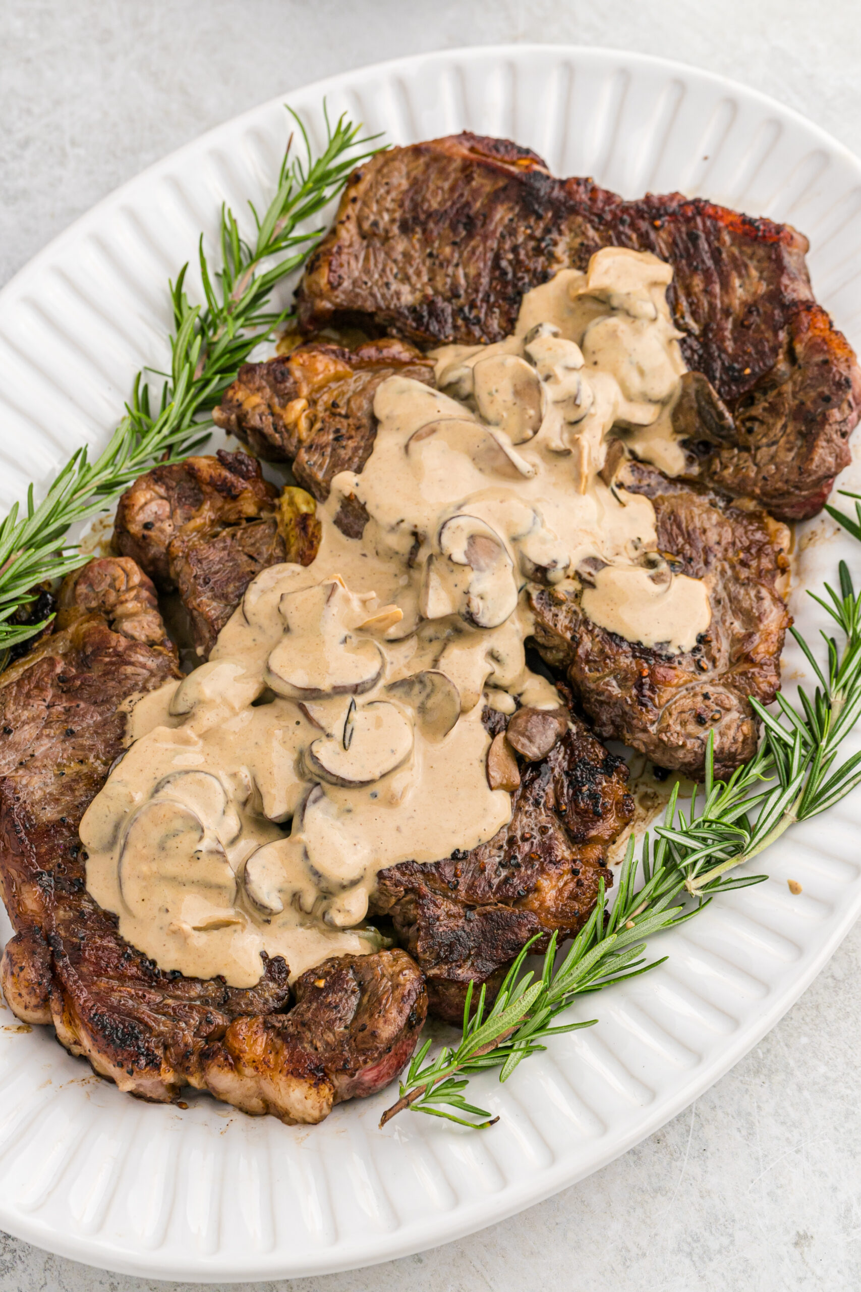 Overhead view of Garlic Butter Steaks on a white serving dish.