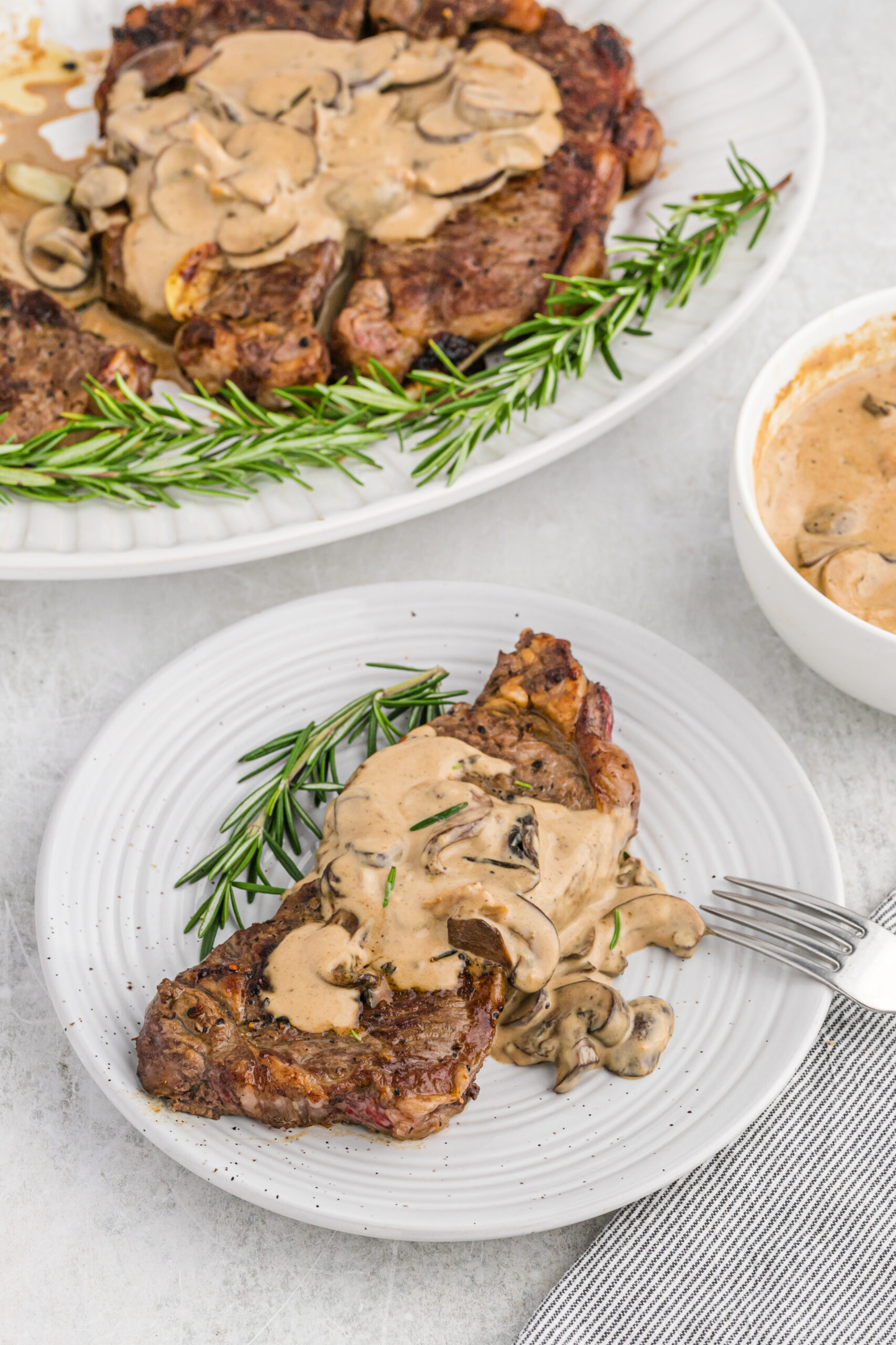 Overhead view of Garlic Butter Steak on a white dish served with a silver fork.