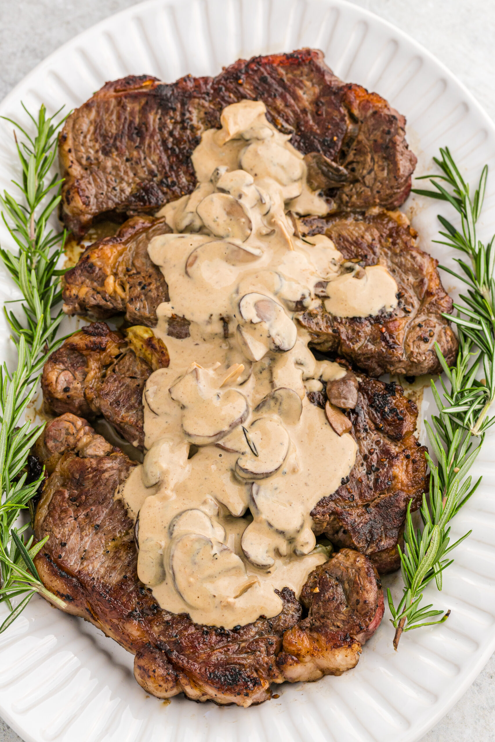 Overhead view of Garlic Butter Steaks on a white serving dish.