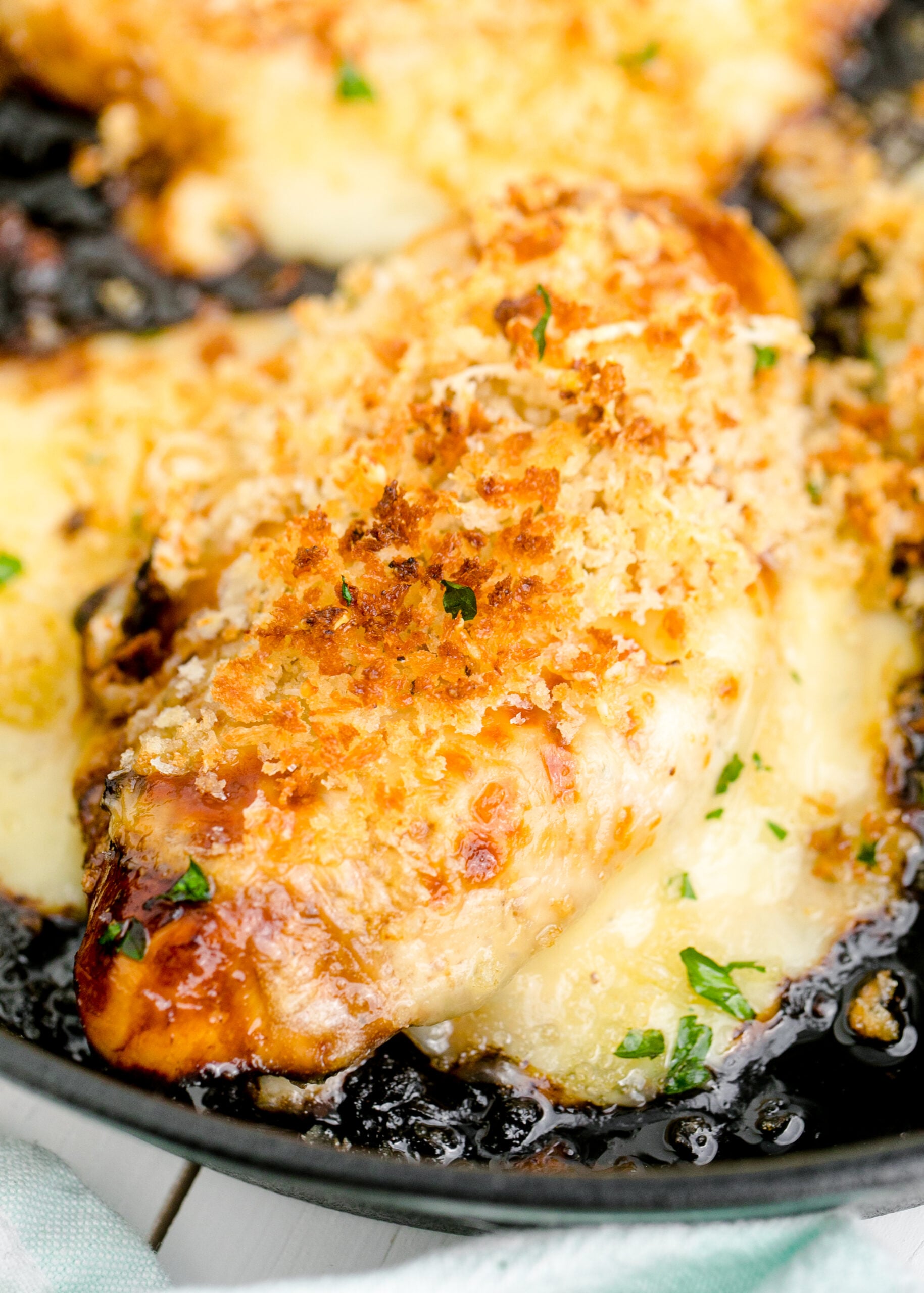 Close up view of Parmesan Crusted Chicken (Longhorn Copycat) in a cast iron skillet.
