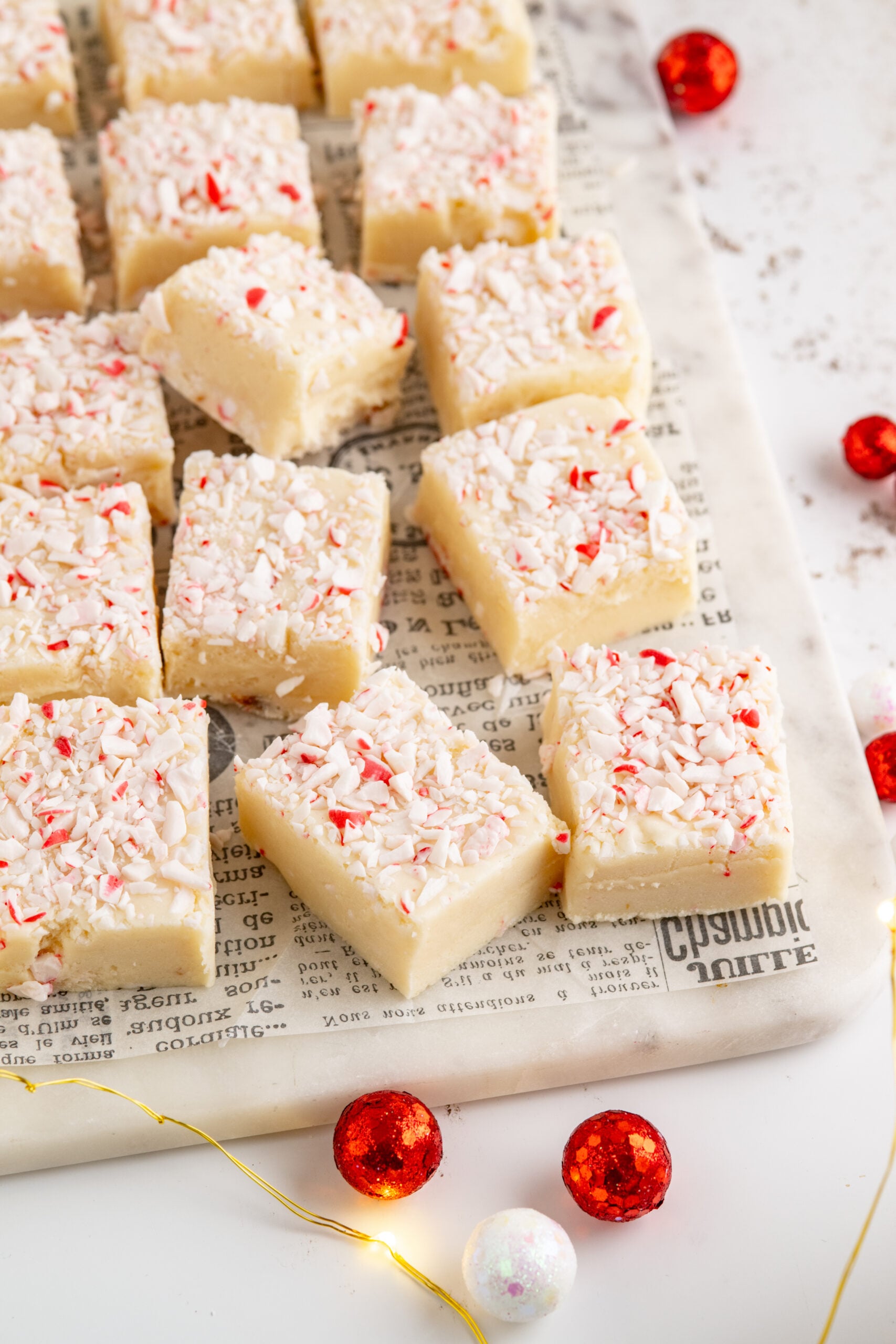 Peppermint fudge cut up into small squares topped with crushed peppermint.