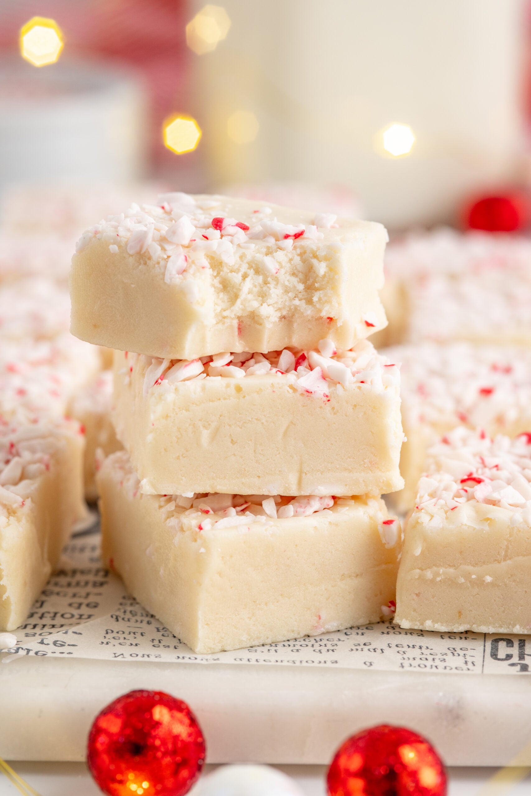 Three pieces of peppermint fudge stacked on top of each other with a bite removed from the top piece.