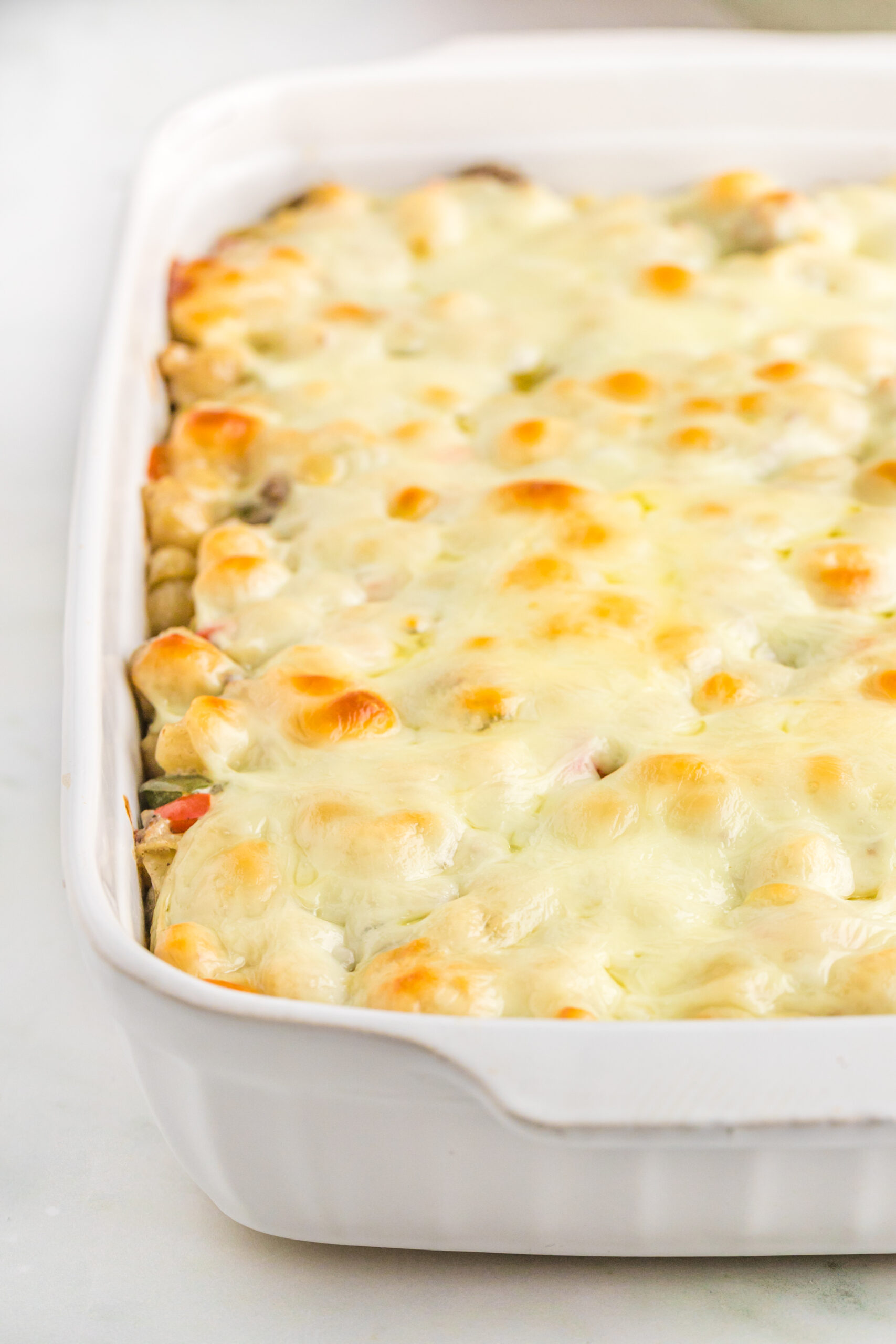 Up close view of Philly Cheesesteak Casserole in a white baking dish.
