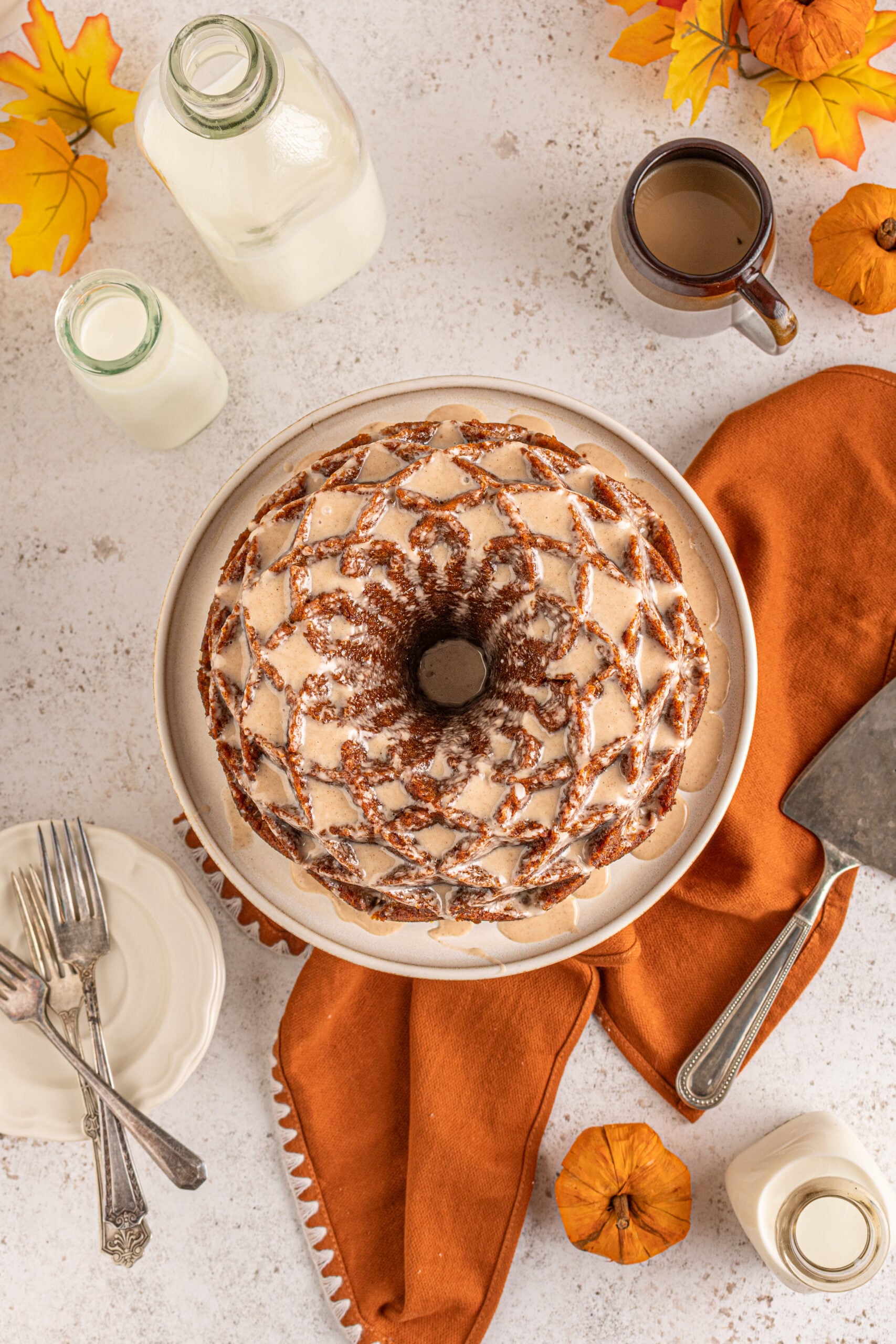 Overhead view of Pumpkin Bundt Cake with Cinnamon Sugar Glaze on a cake stand.