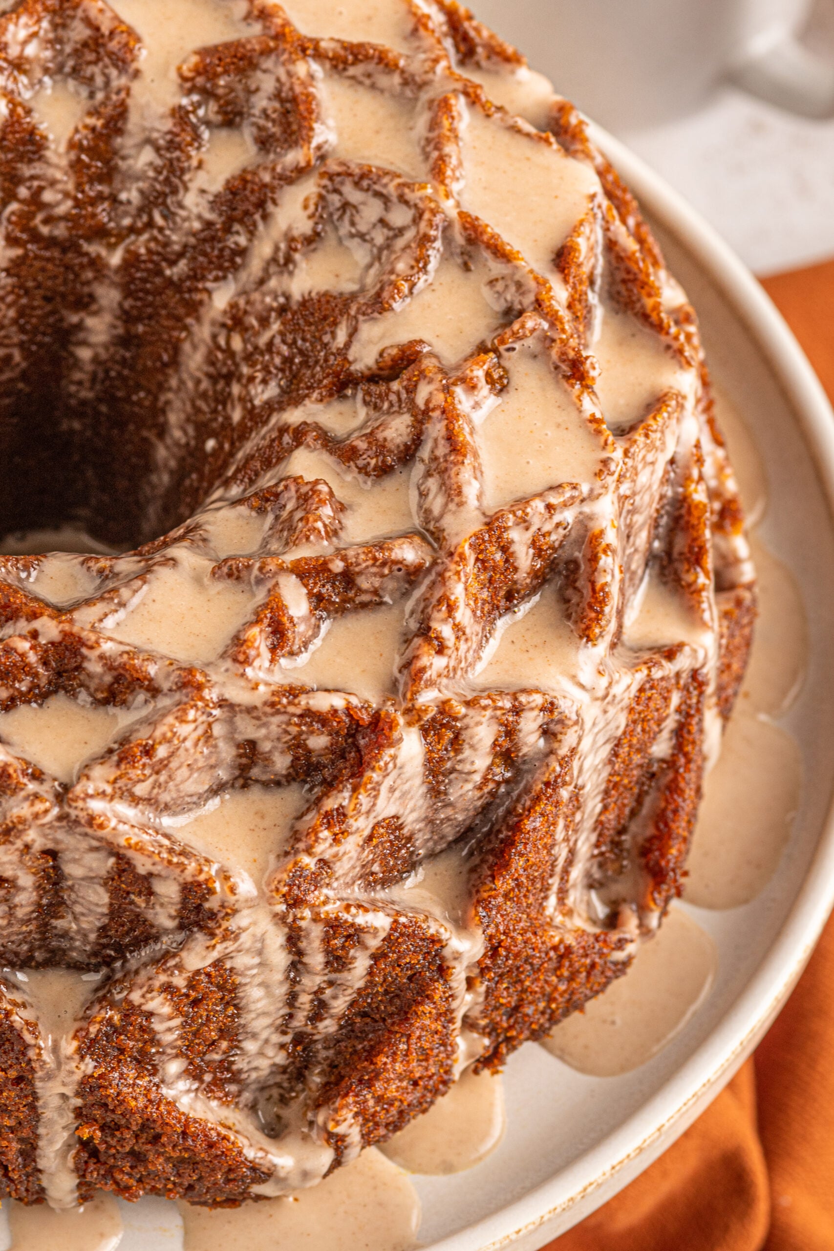 Close up view of Pumpkin Bundt Cake with Cinnamon Sugar Glaze on a cake stand.