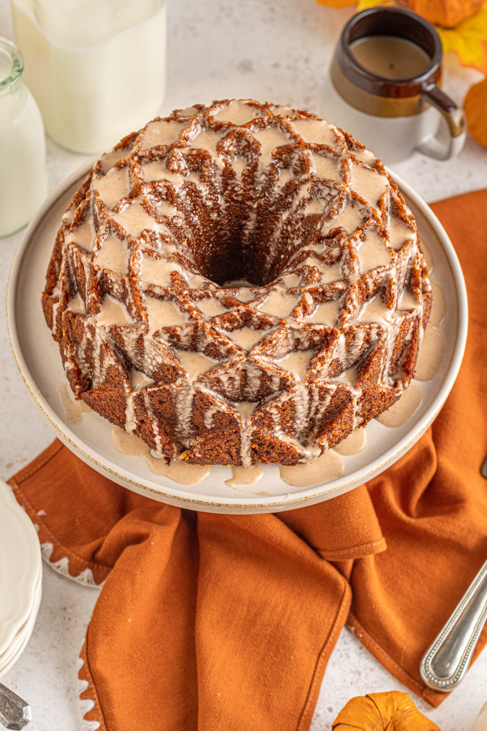 View of Pumpkin Bundt Cake with Cinnamon Sugar Glaze on a cake stand.