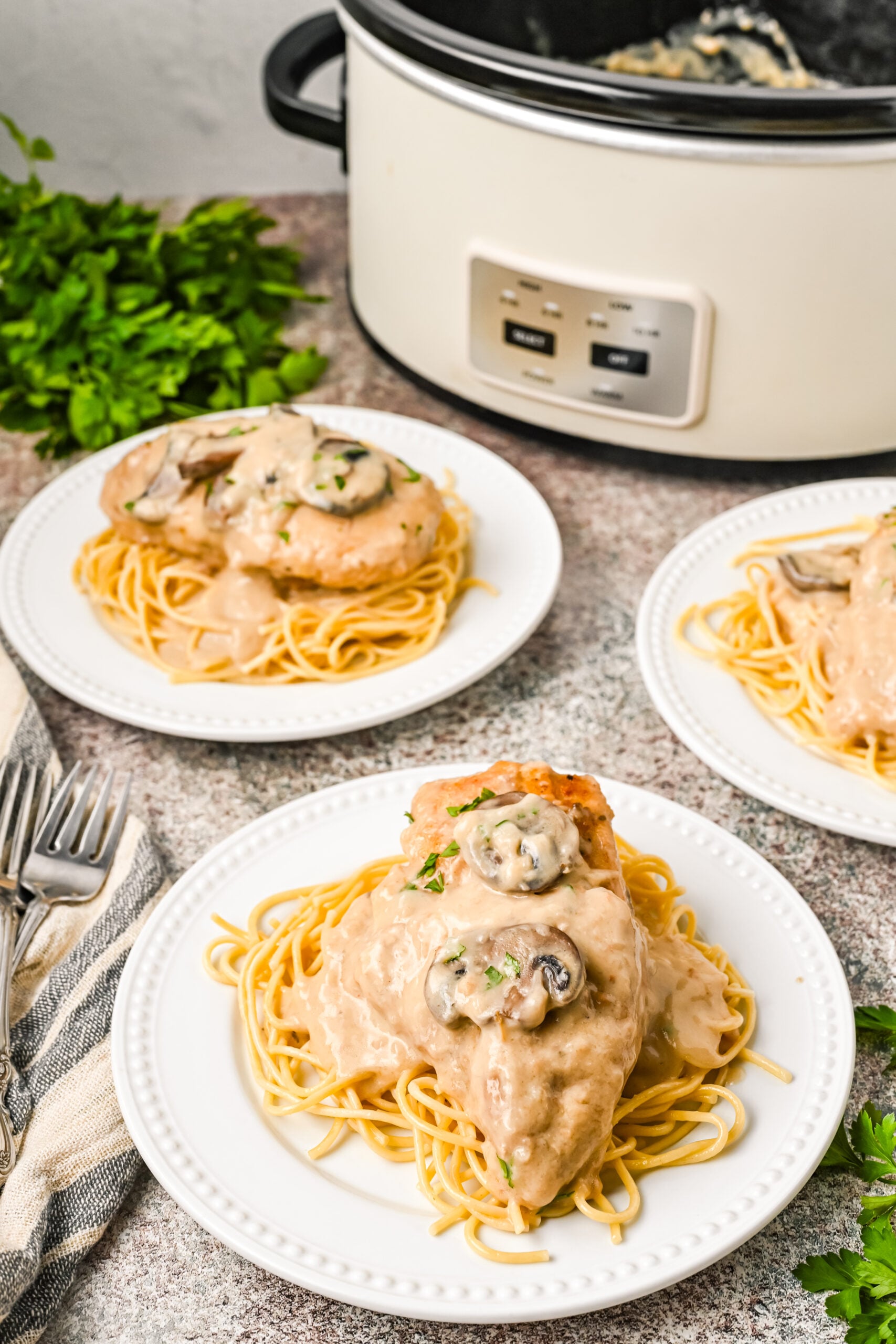 Plated Chicken Marsala on top of spaghetti noodles.