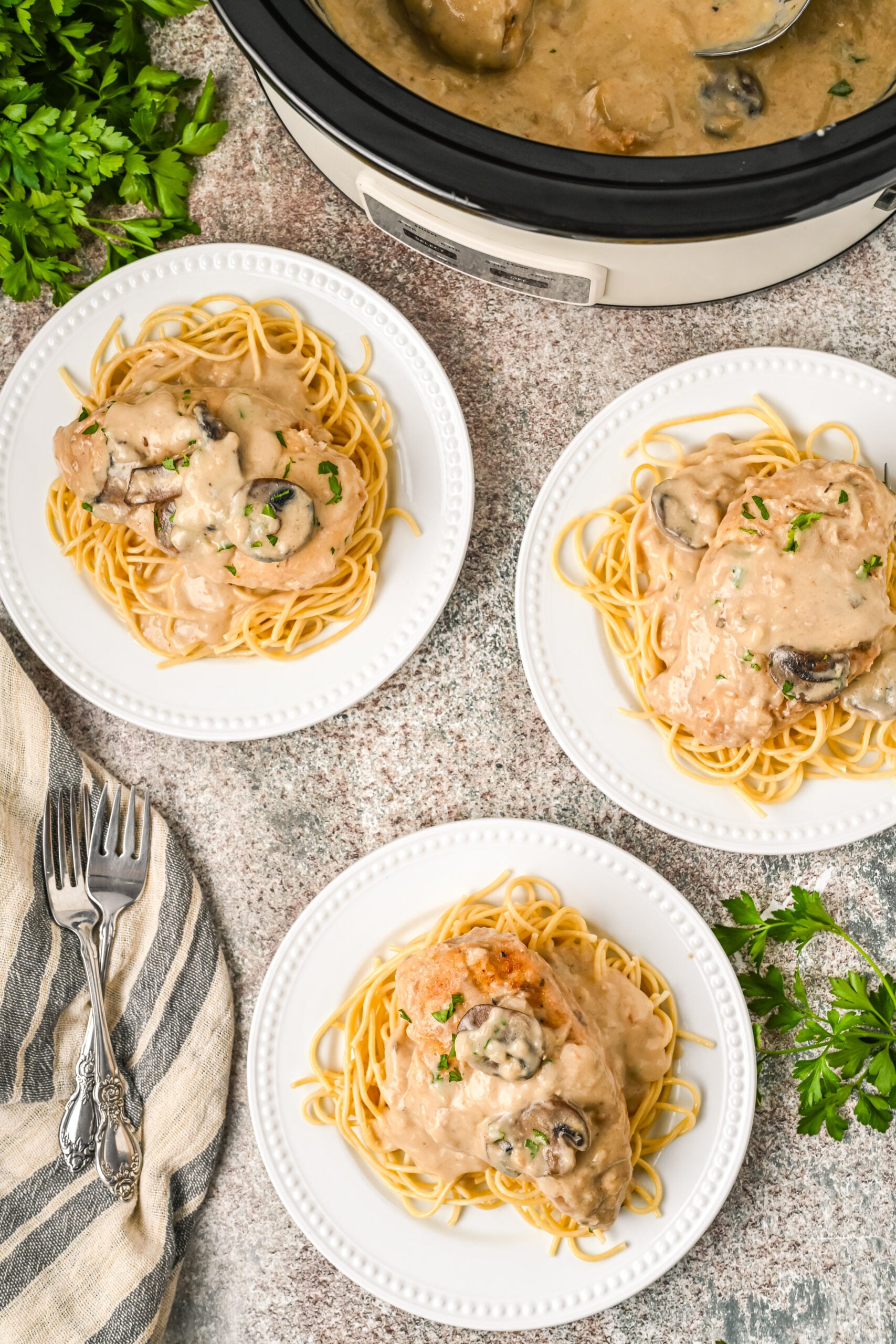 Plated Chicken Marsala on top of spaghetti noodles.
