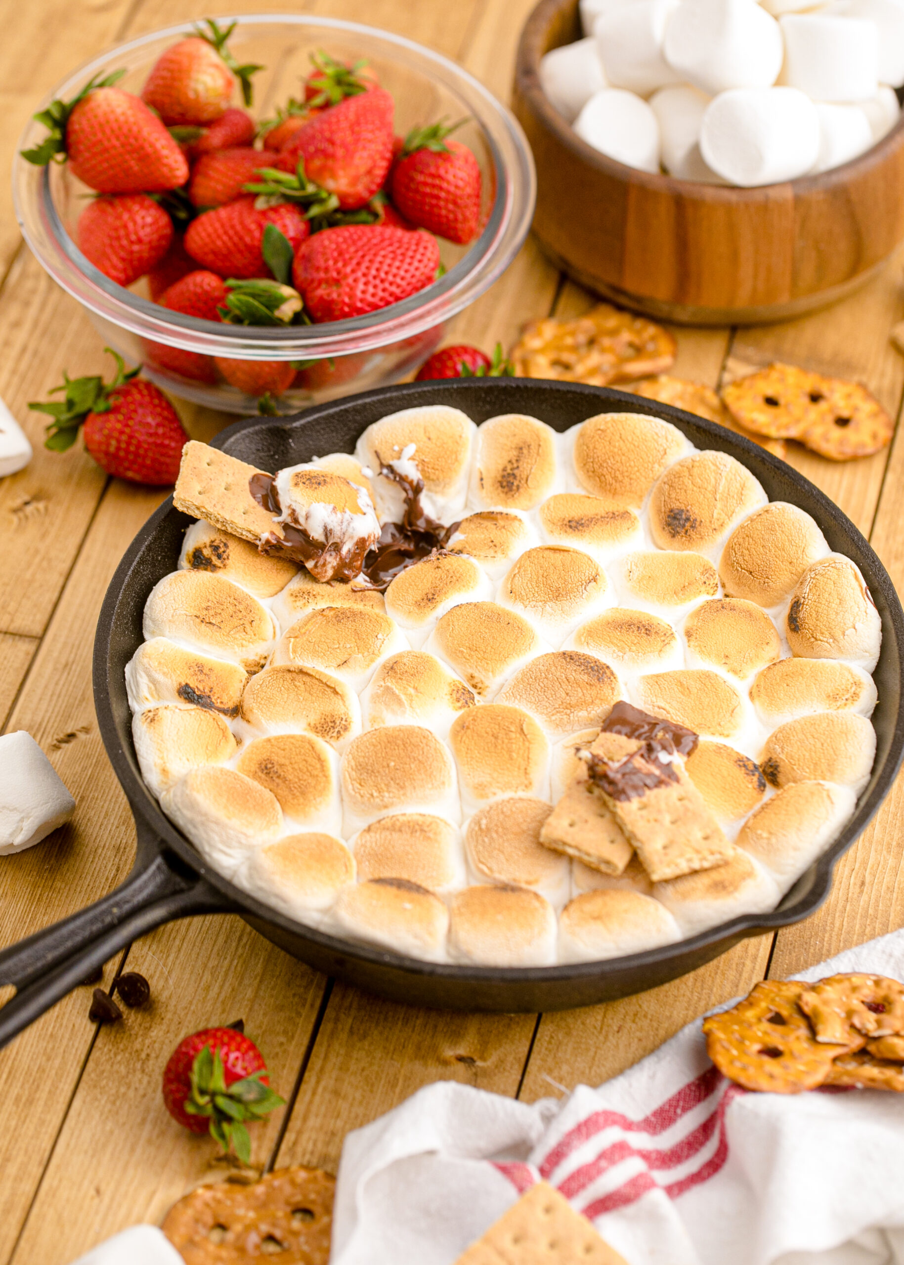 Front view of S'mores dip in a cast iron skillet with graham crackers covered in the dip sitting on top.