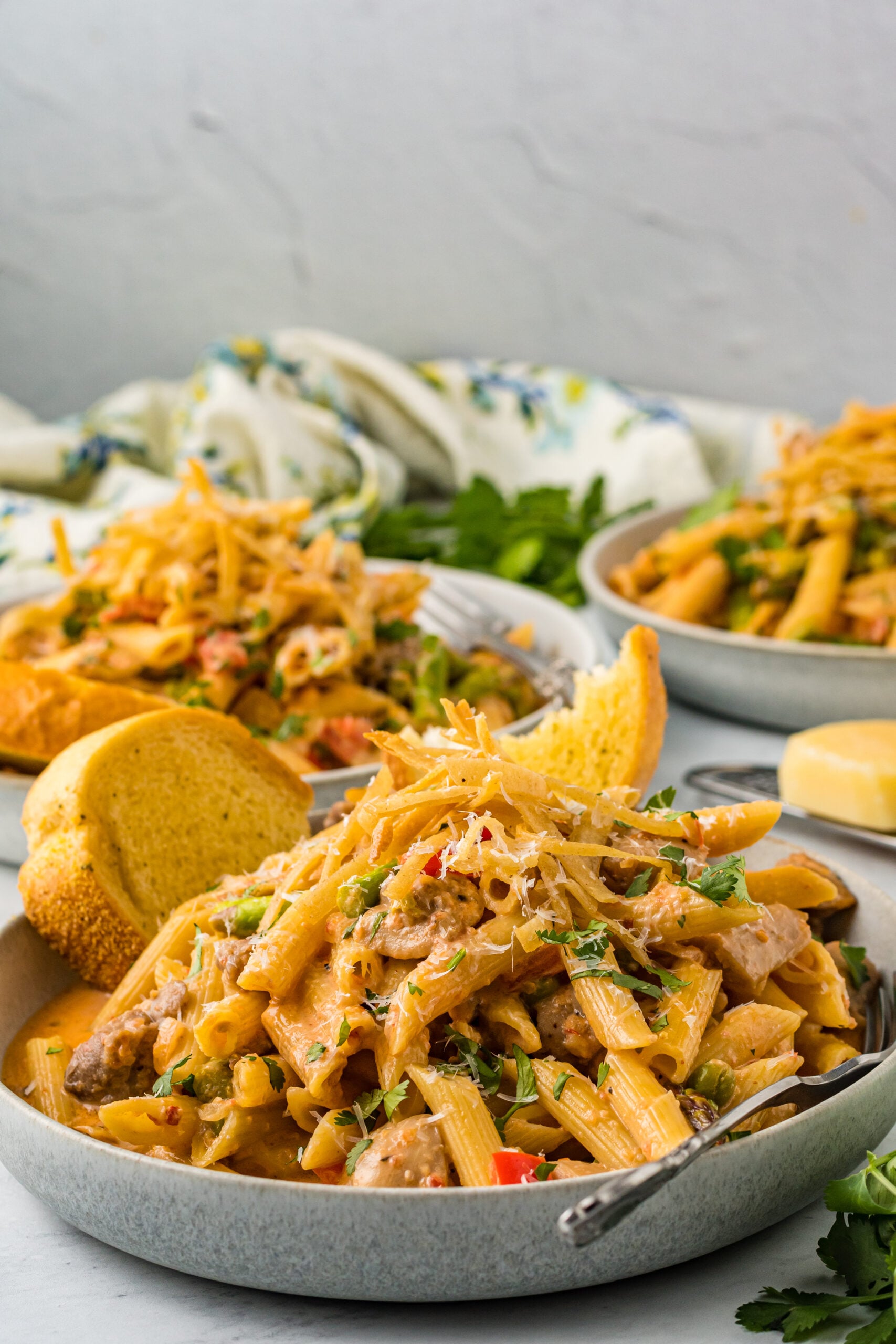 Side view of Cajun Chicken Pasta served in a dish with garlic bread.