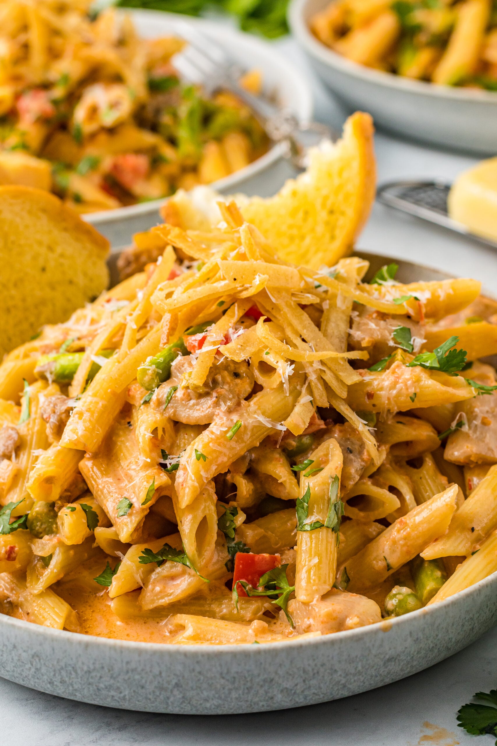 Cloe up view of Cajun Chicken Pasta served in a dish with garlic bread.