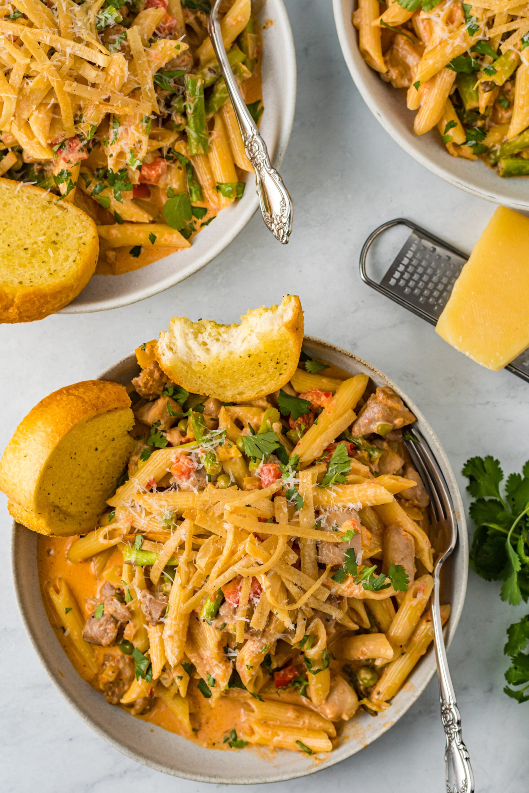 Overhead view of Cajun Chicken Pasta served in a dish with garlic bread.