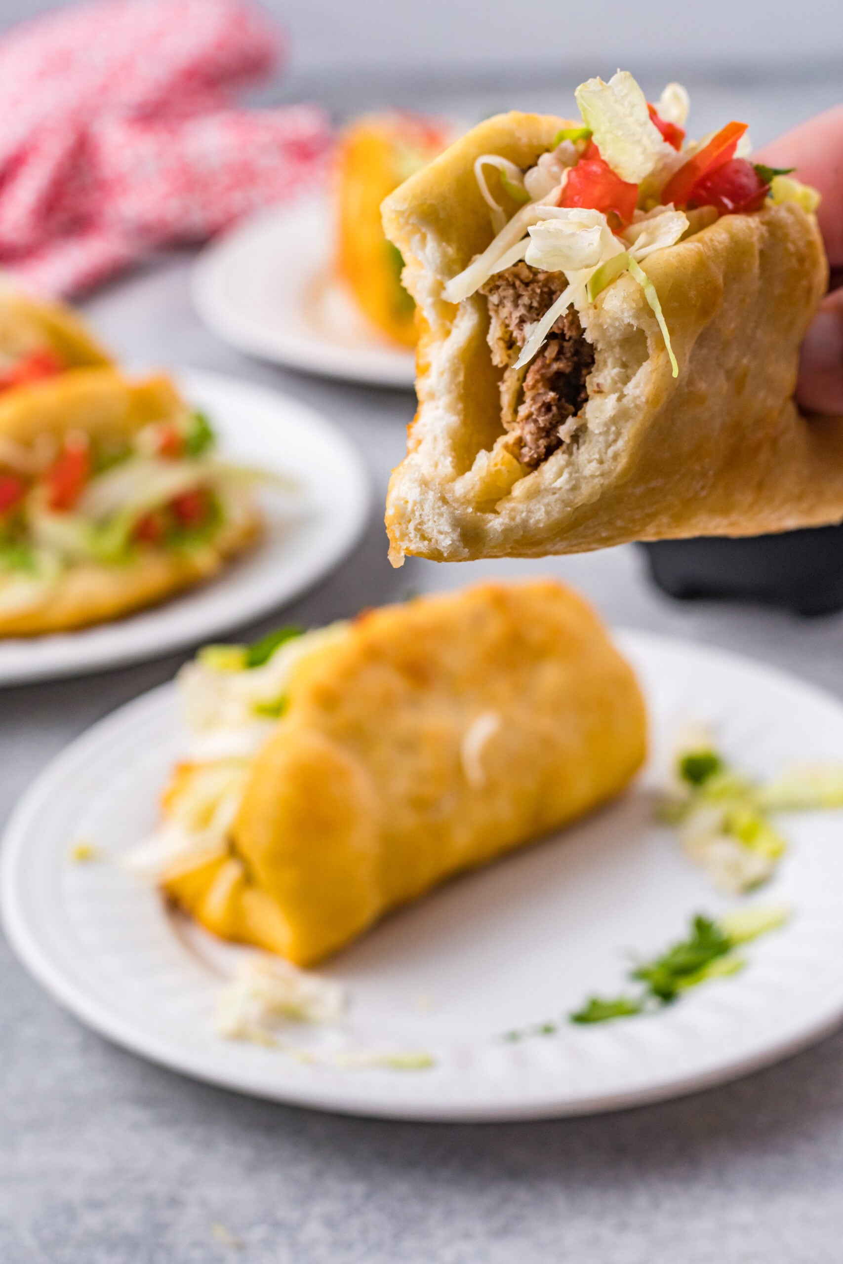 Front view of a Taco Bell Chalupa being held with a bite removed.