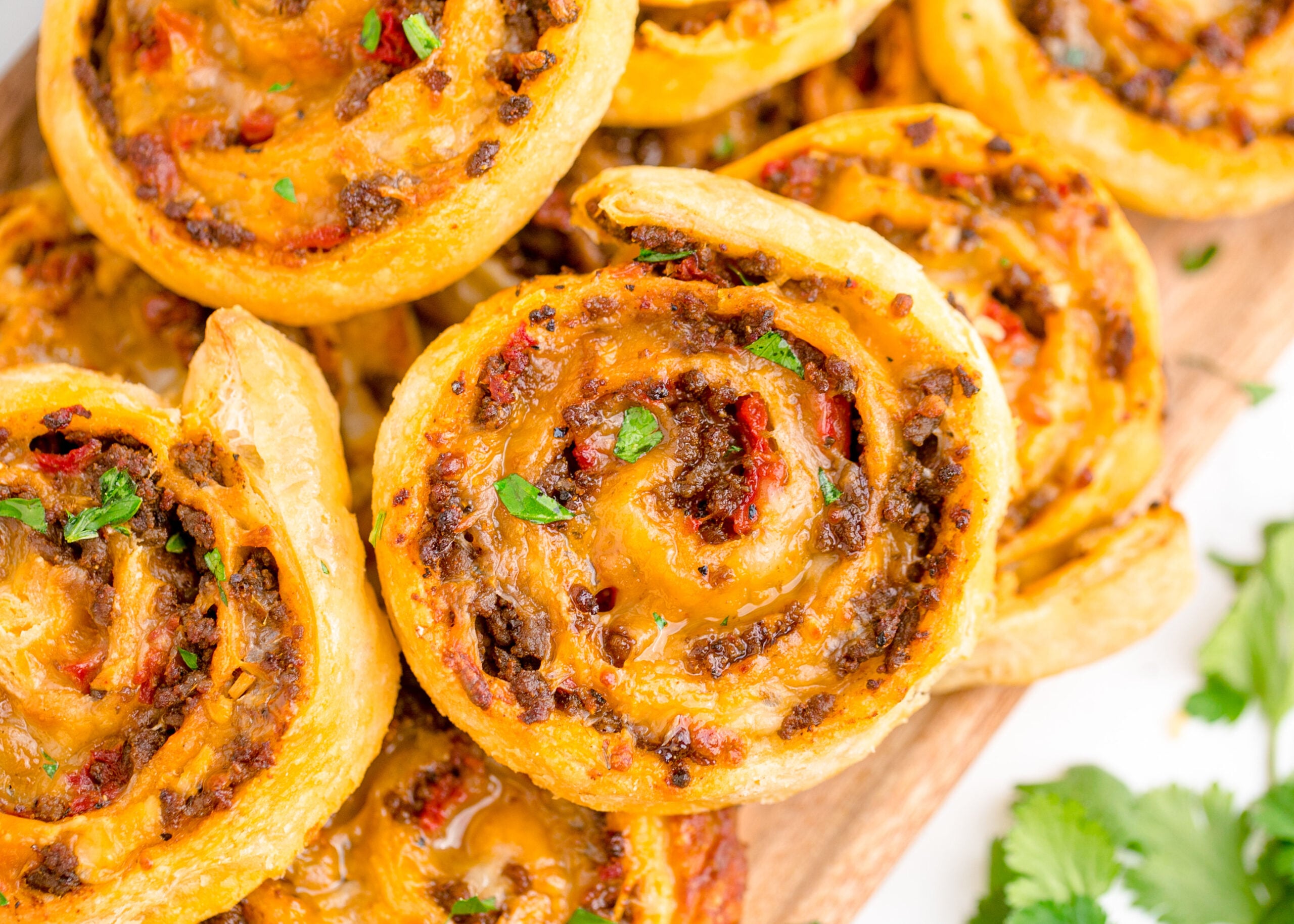 Taco pinwheels up close showing the gooey cheese and beef inside 