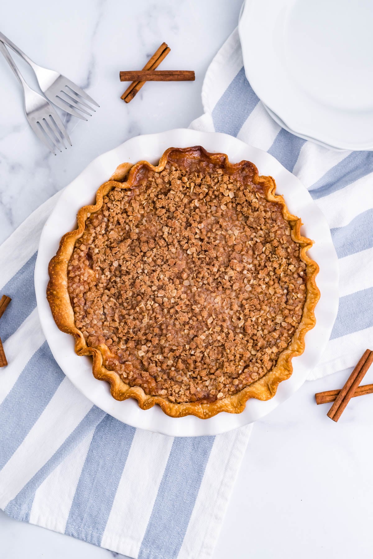 Overhead view of Apple Crumb Cheesecake Pie in a white pie dish.