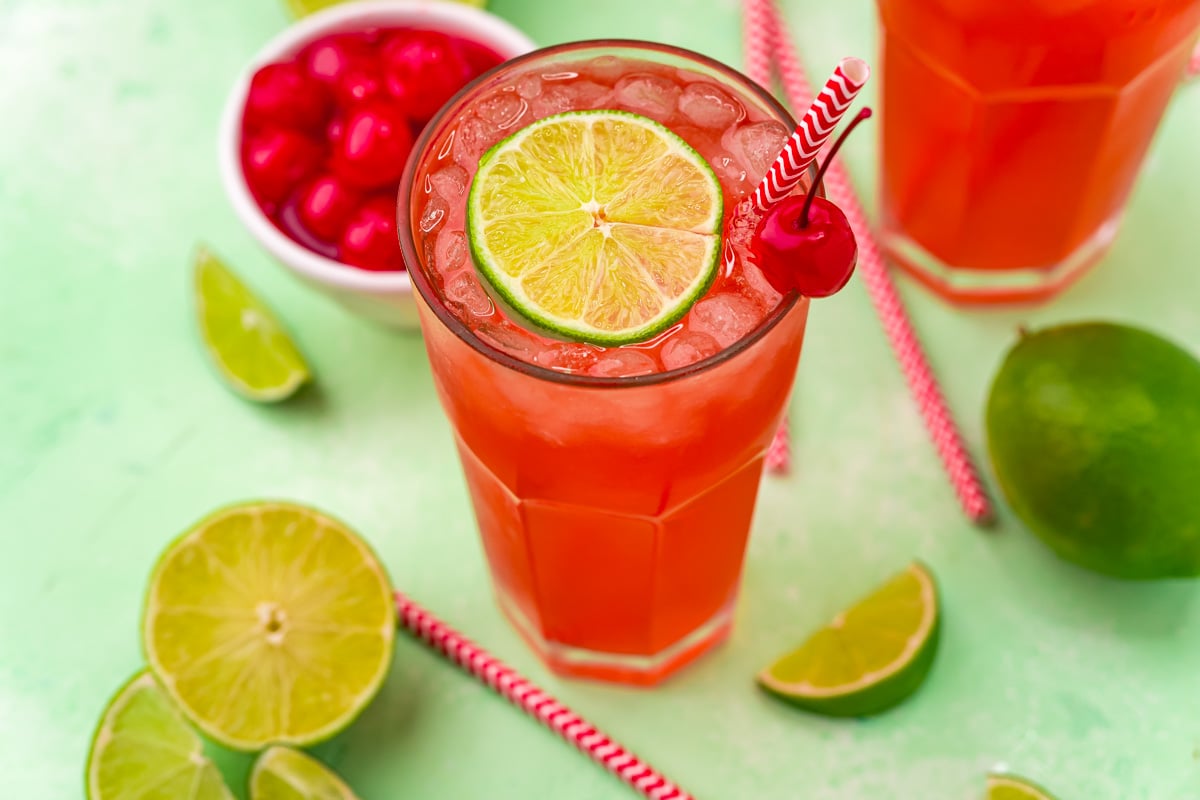 45 degree view of Cherry Limeade garnished with a lime and cherry.