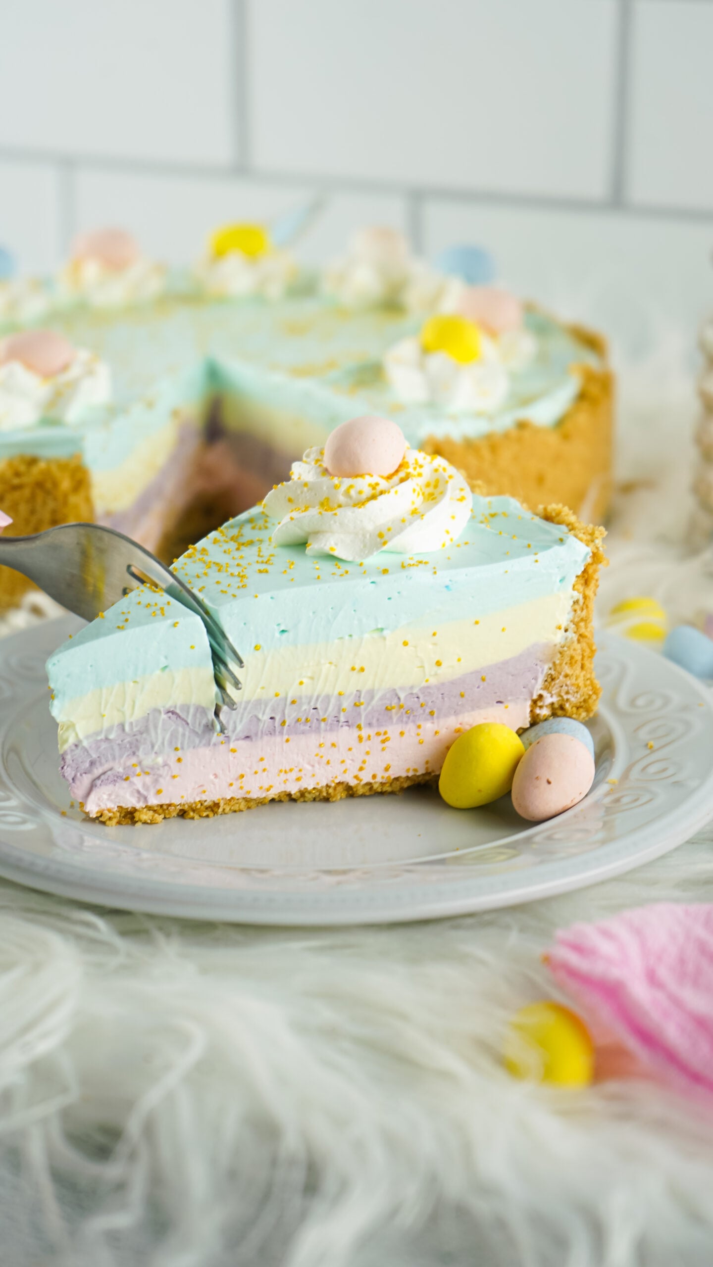Side view of a slice of Easter Kool Aid Pie with a silver fork removing a bite.

