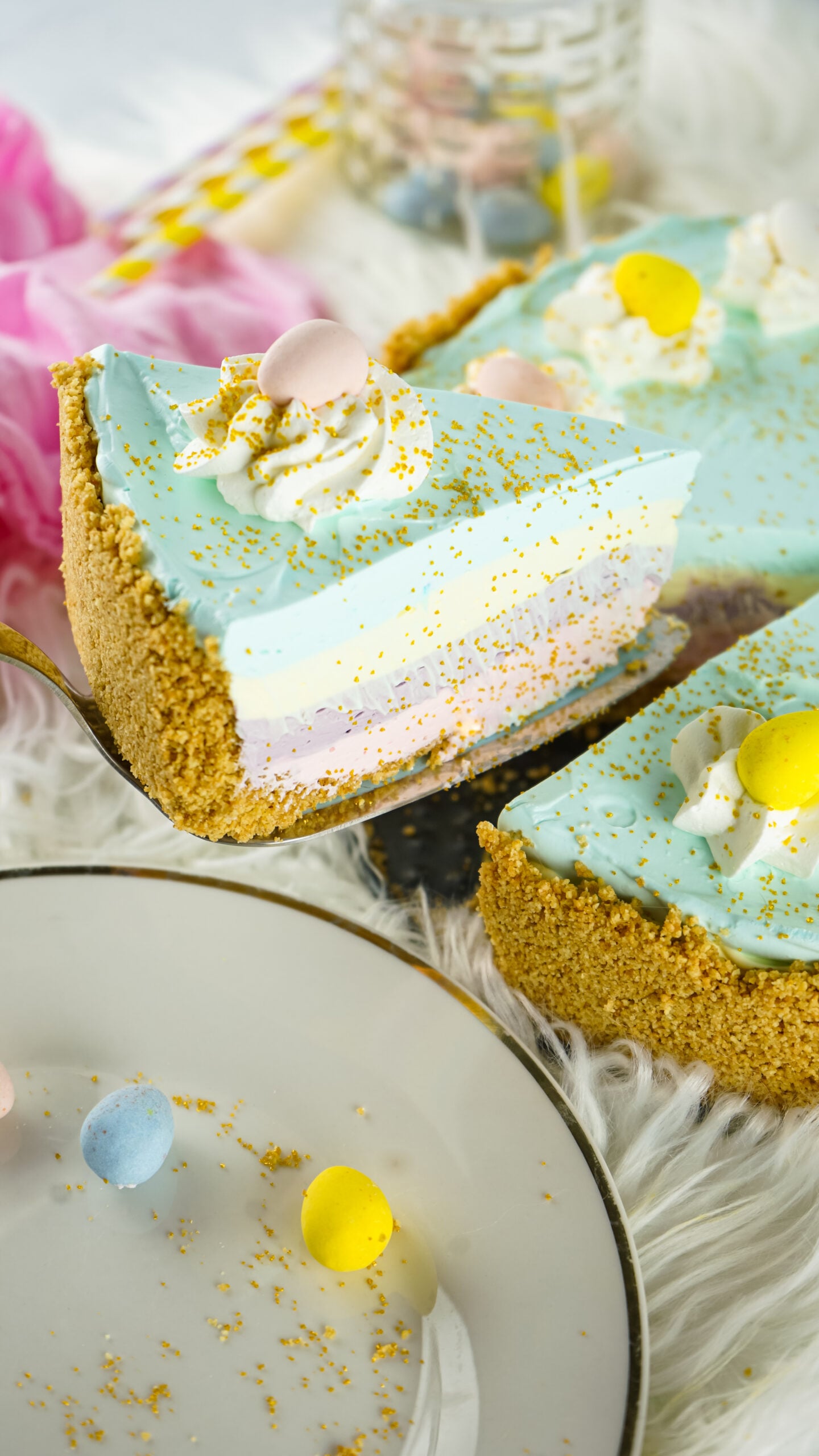 Side view of a slice of Easter Kool Aid Pie on a gold cake server.