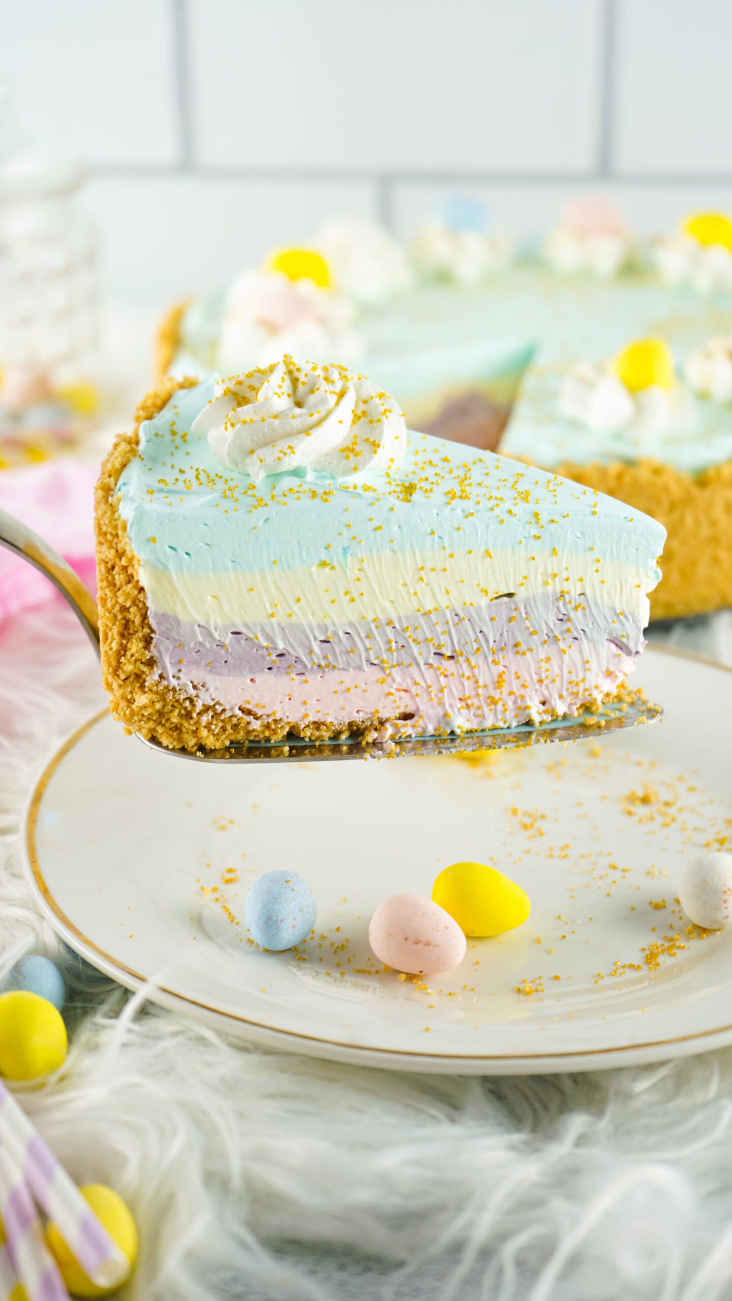 Side view of a slice of Easter Kool Aid Pie on a gold cake server.