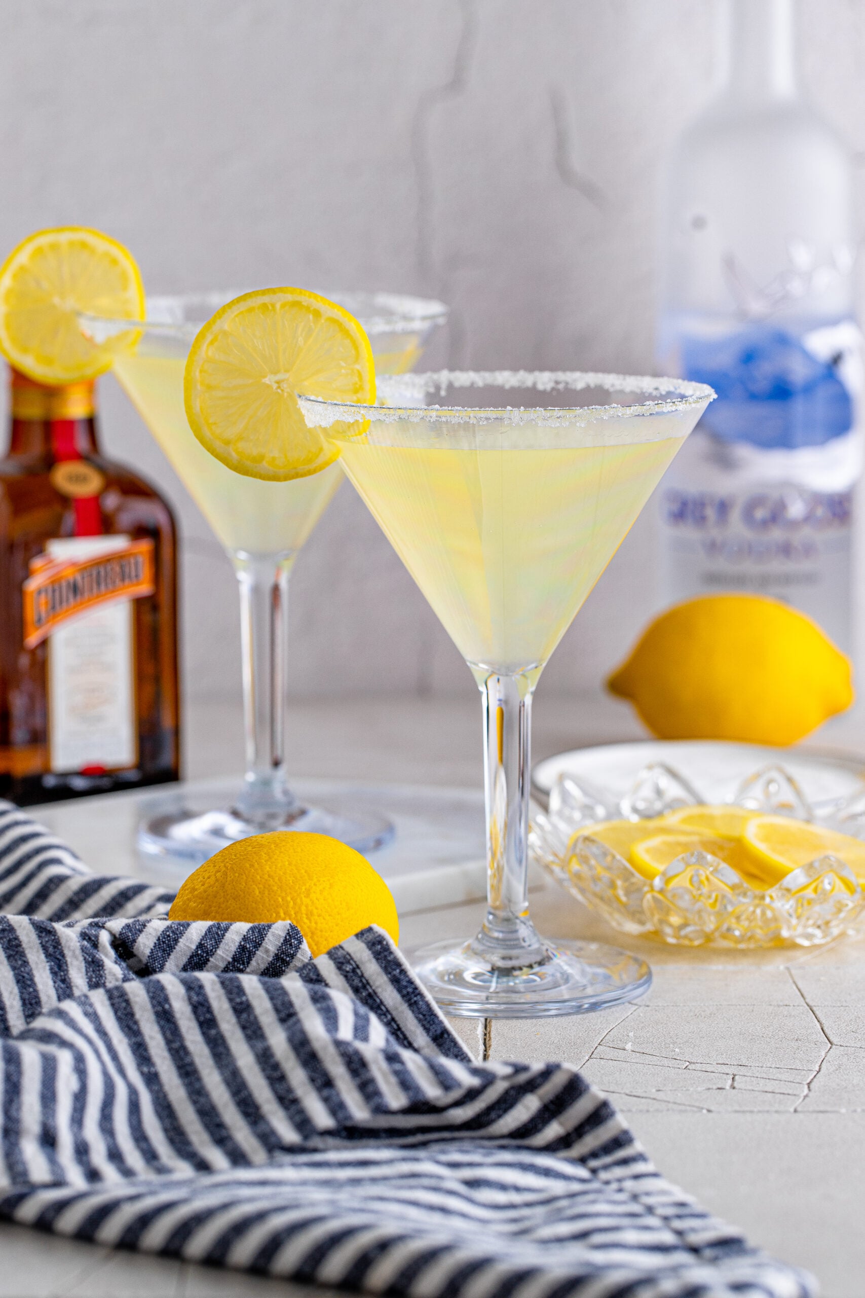 Two Lemon Drop Martinis in martini glasses with a lemon slice. 
