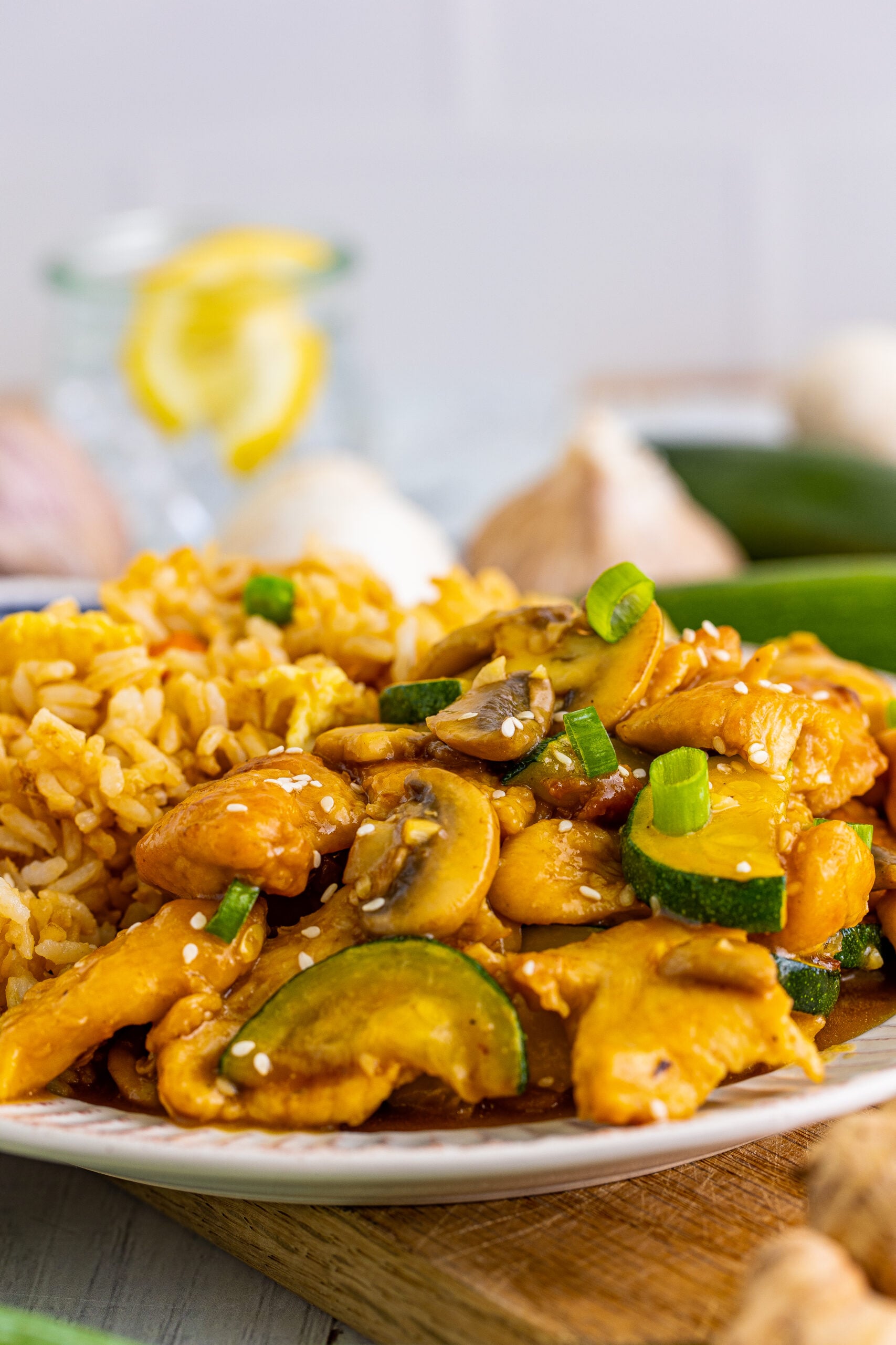 Close up view of Panda Express Mushroom Chicken on a white dish served with fried rice.