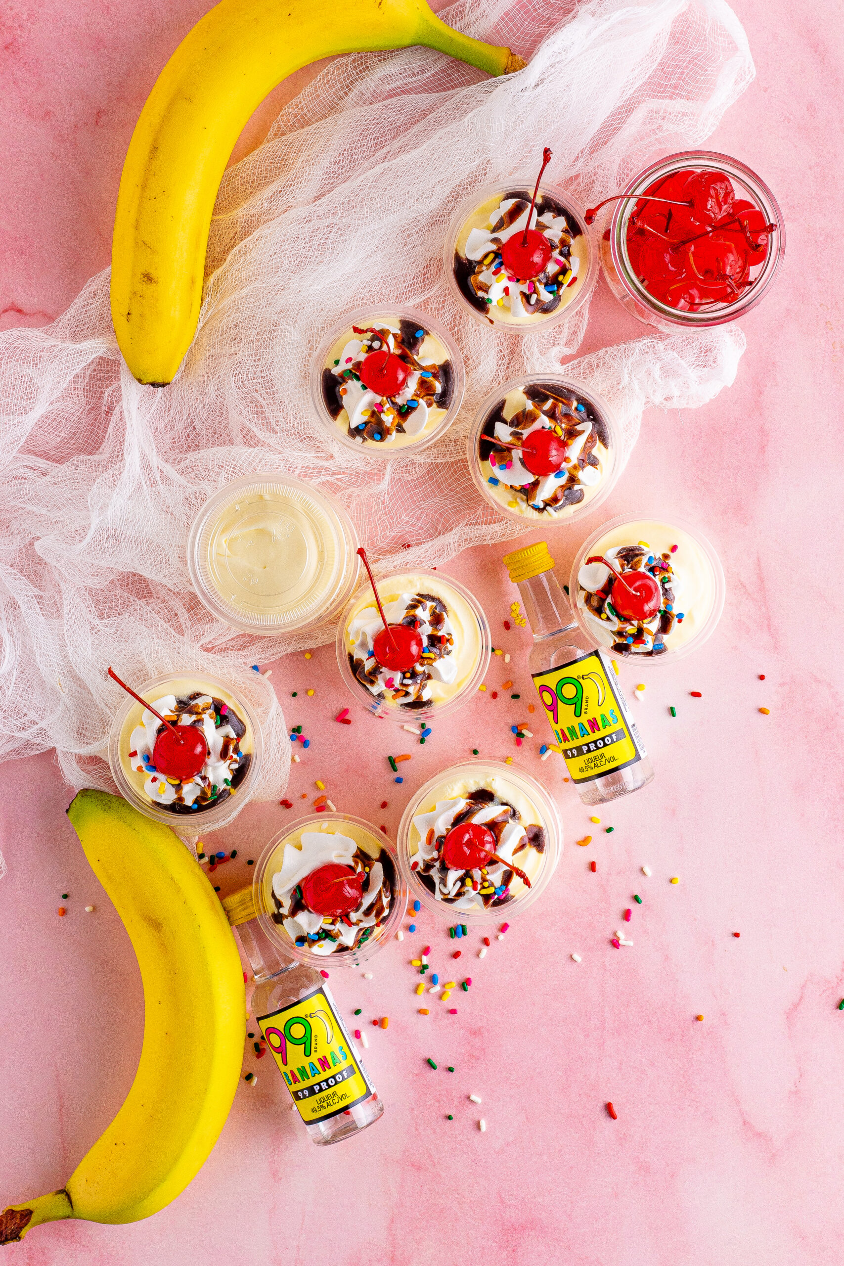 Overhead view of Banana Split Shots surrounded by rainbow sprinkles.