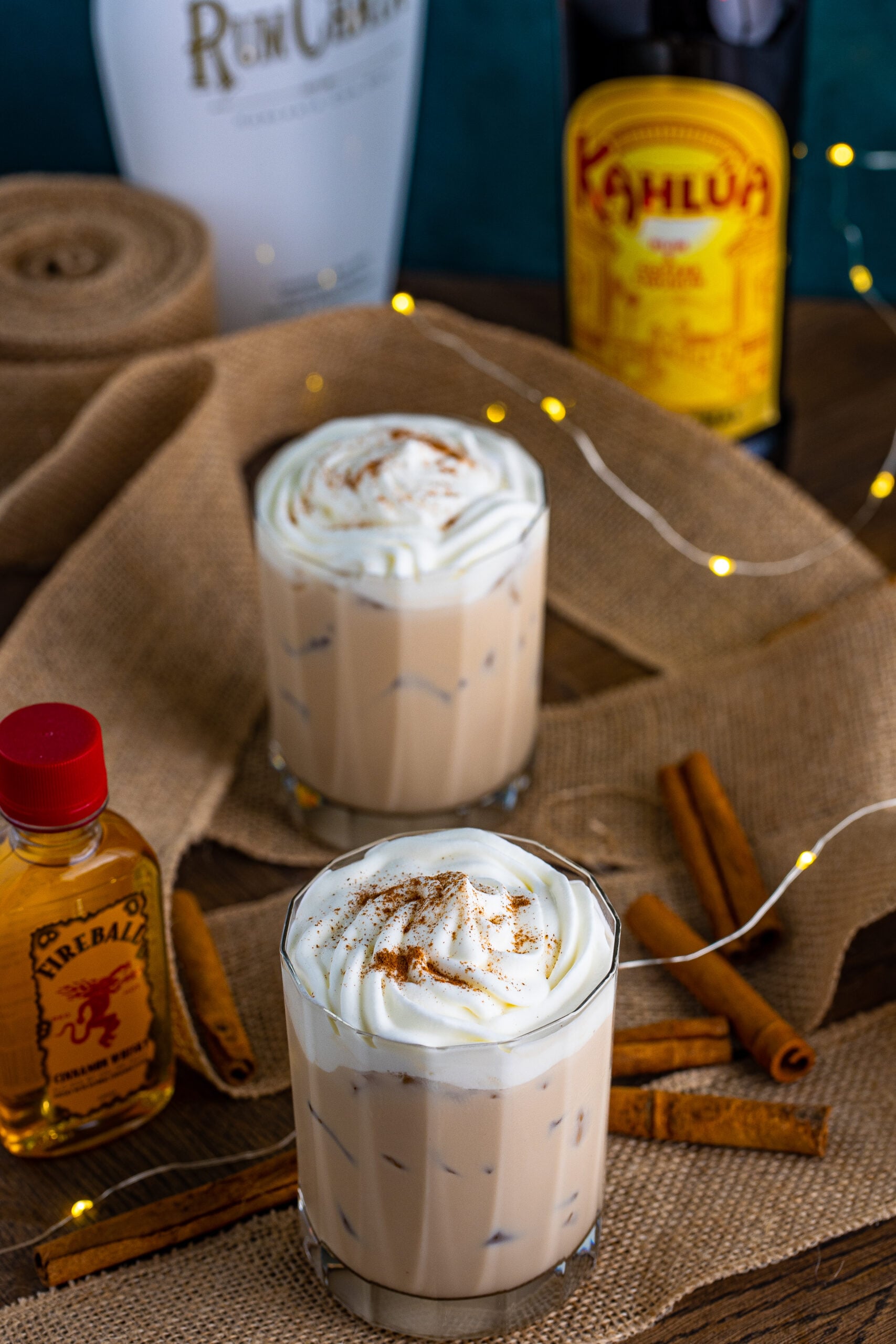 View of Cinnamon Roll Cocktail surrounded with cinnamon sticks.
