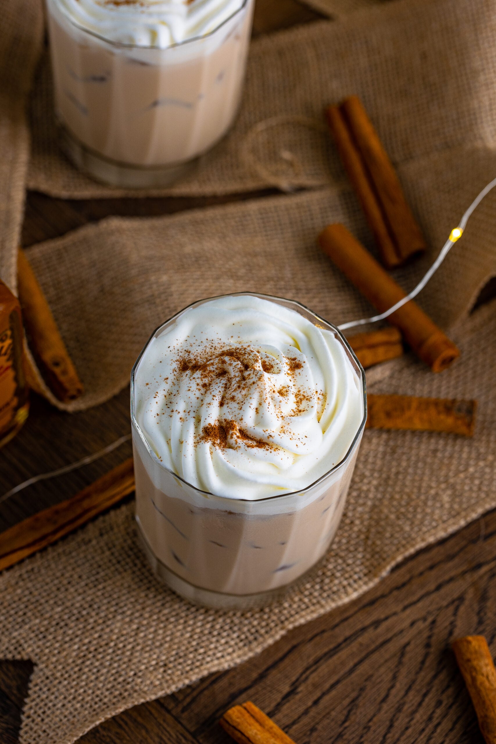 Overhead view of Cinnamon Roll Cocktail Surrounded by cinnamon sticks.