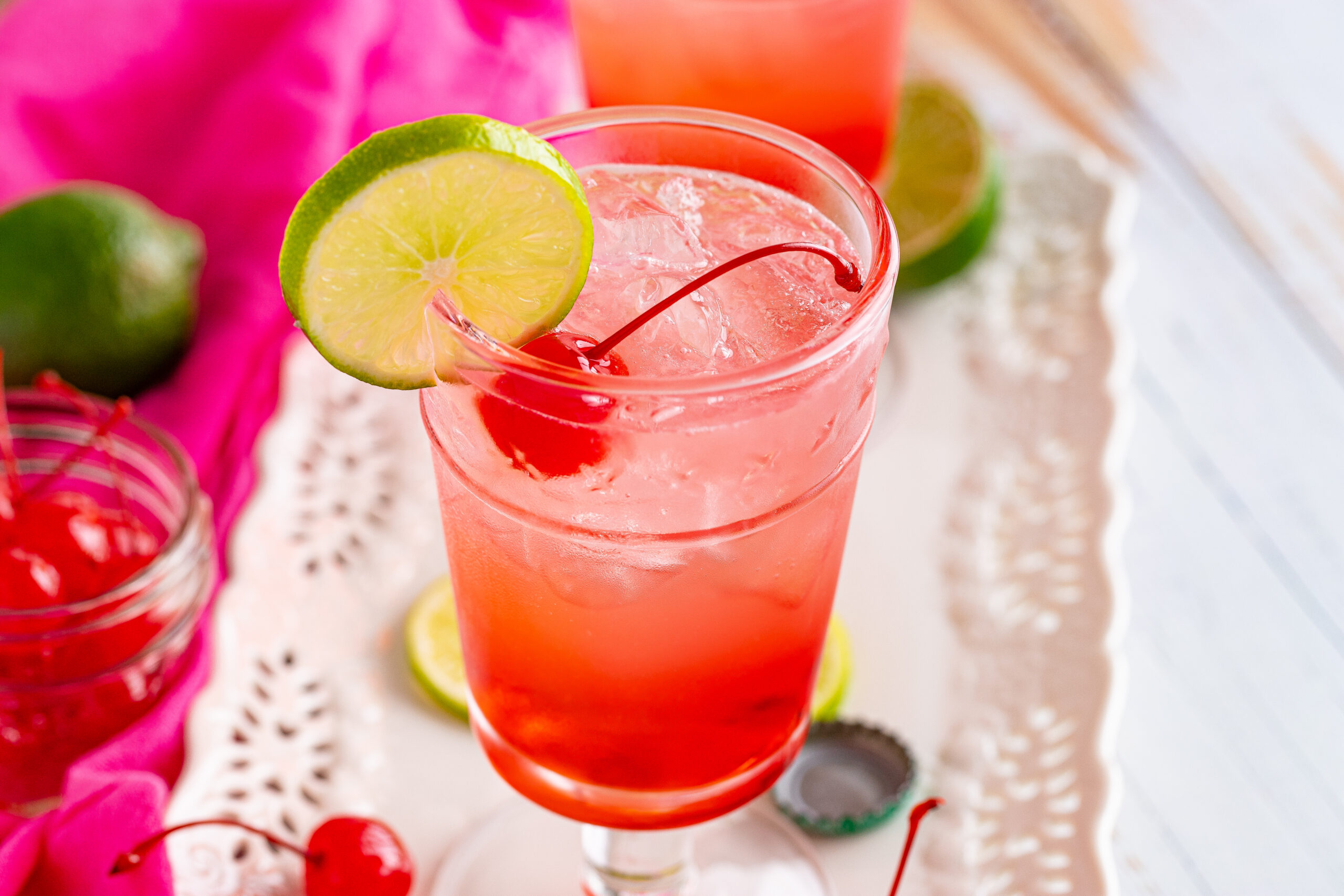 45 degree view of Dirty Shirley Temple garnished with a lime slice.