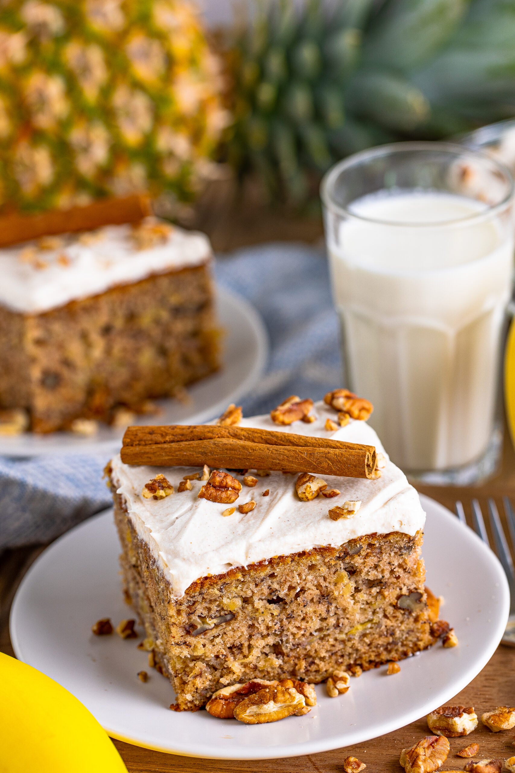 Front view of Hummingbird Cake on a white dish garnished cinnamon stick.
