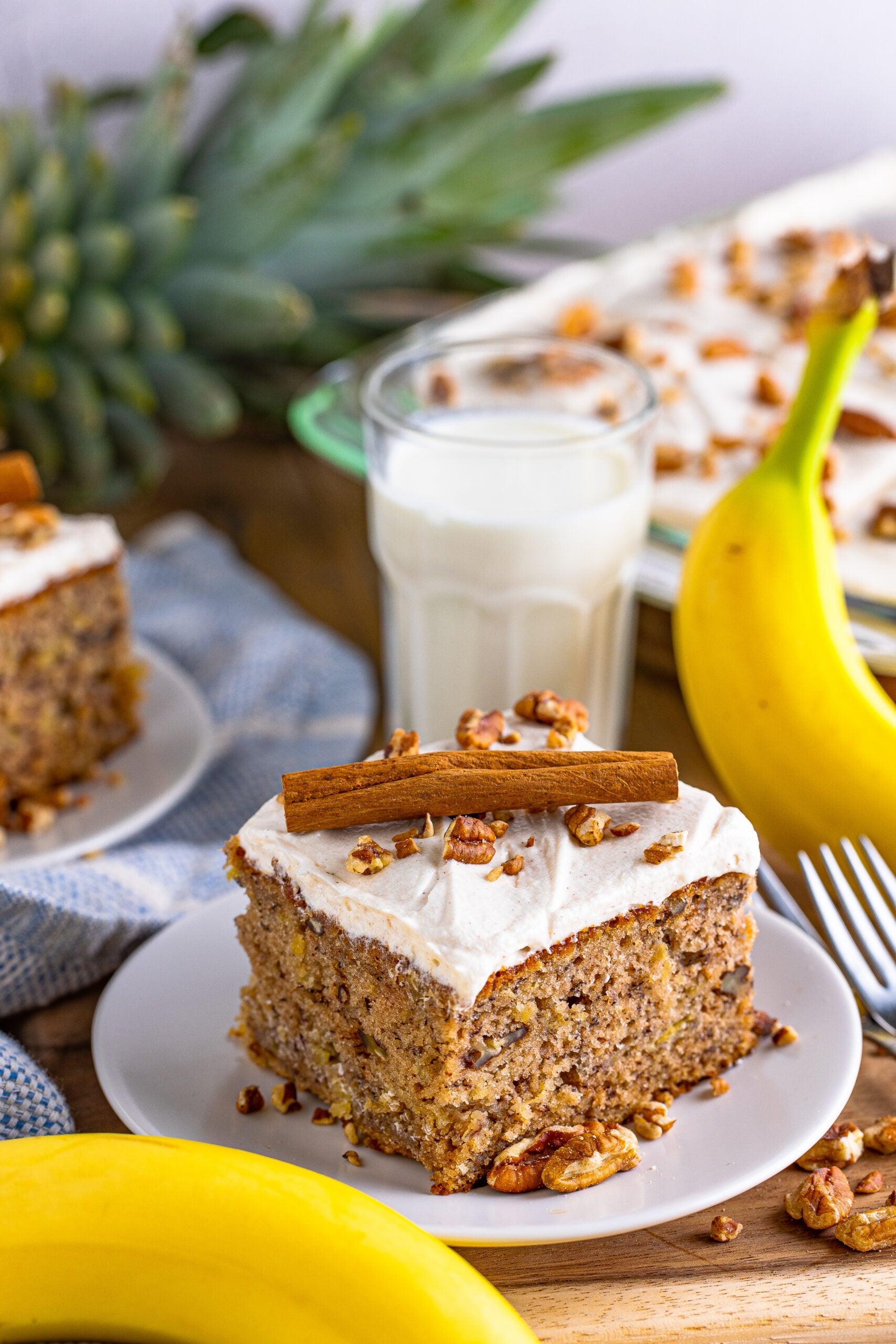 Front view of Hummingbird Cake on a white dish garnished cinnamon stick.