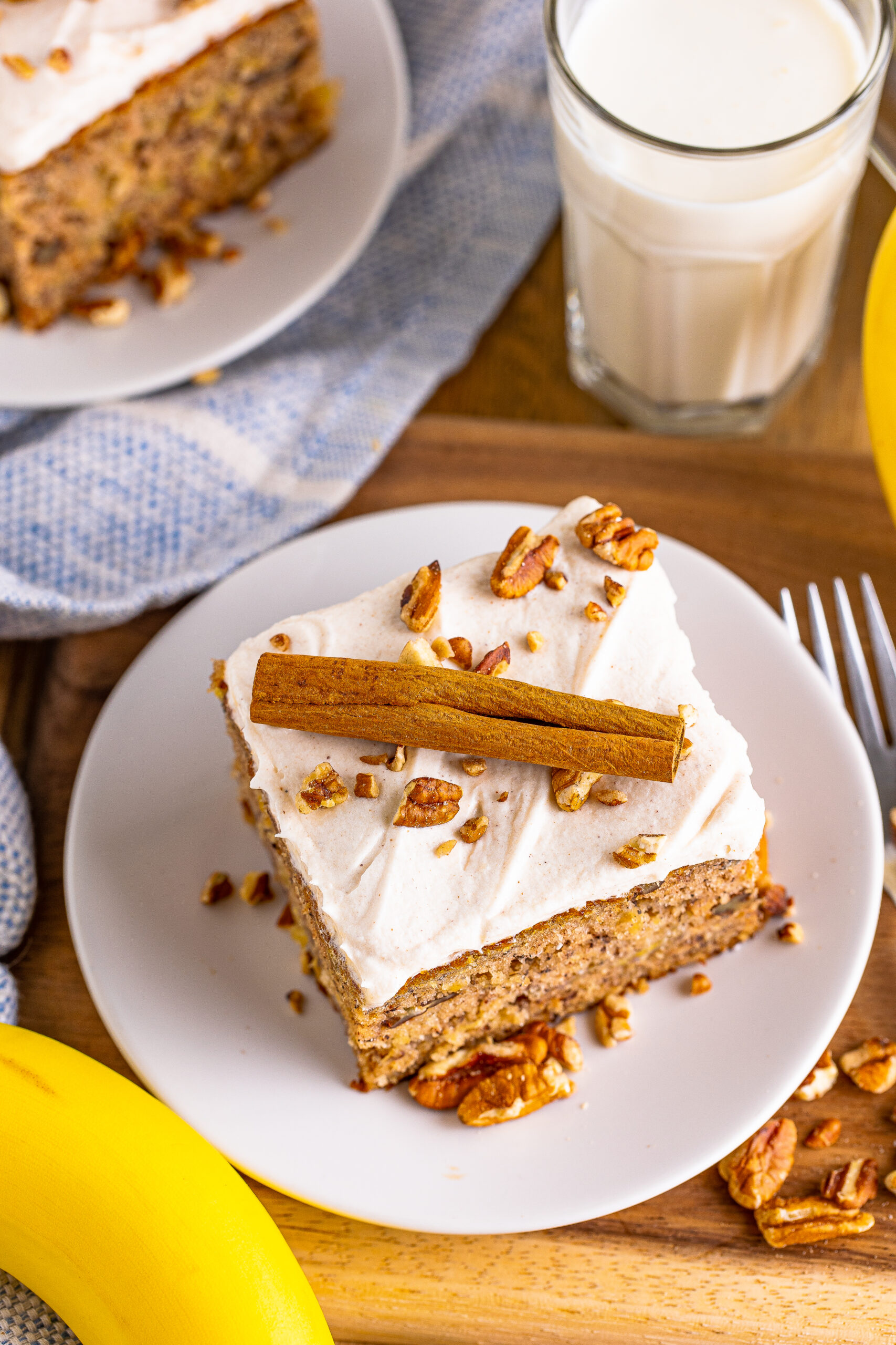 Overhead view of Hummingbird Cake on a white dish garnished cinnamon stick.