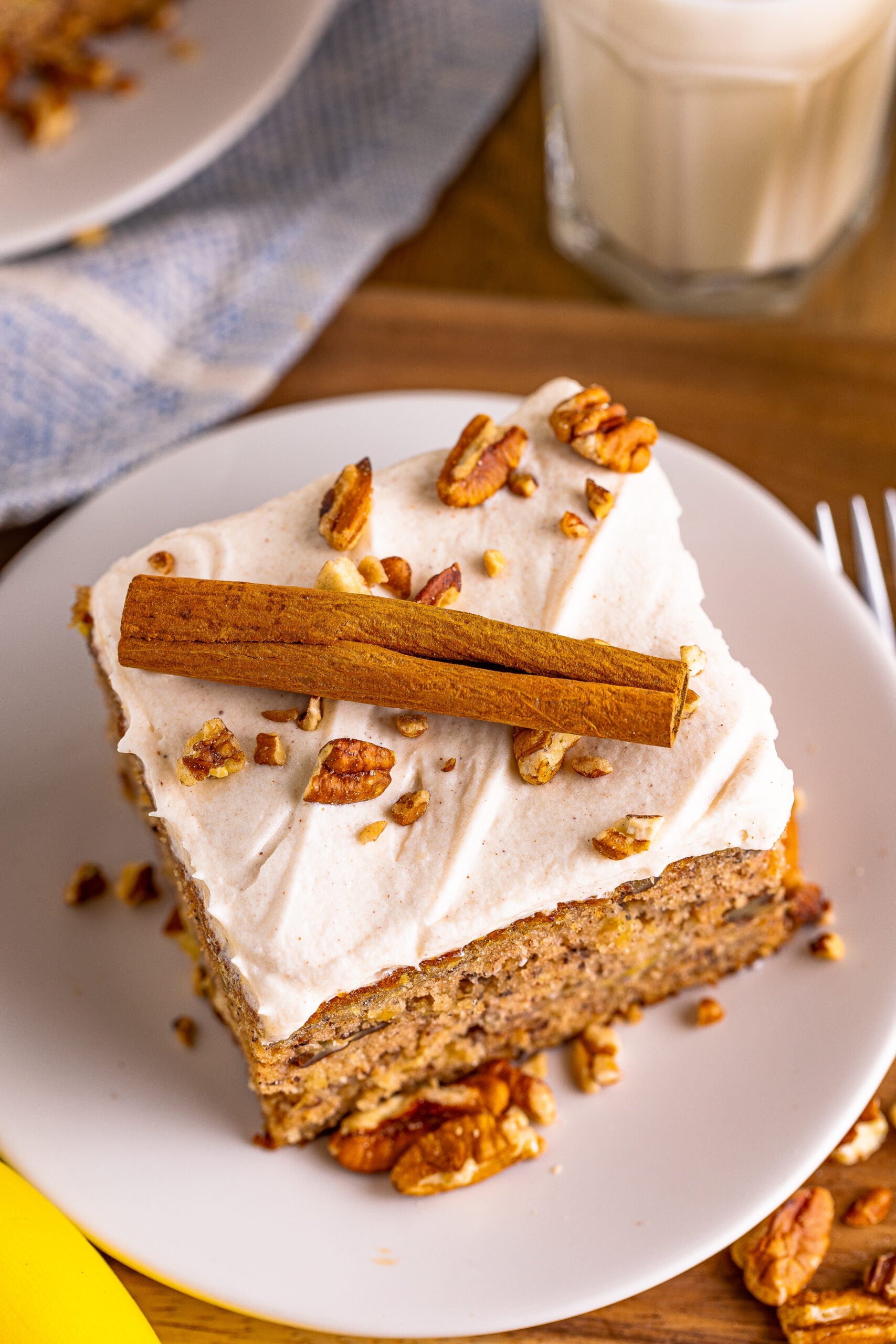 Overhead view of Hummingbird Cake on a white dish garnished cinnamon stick.