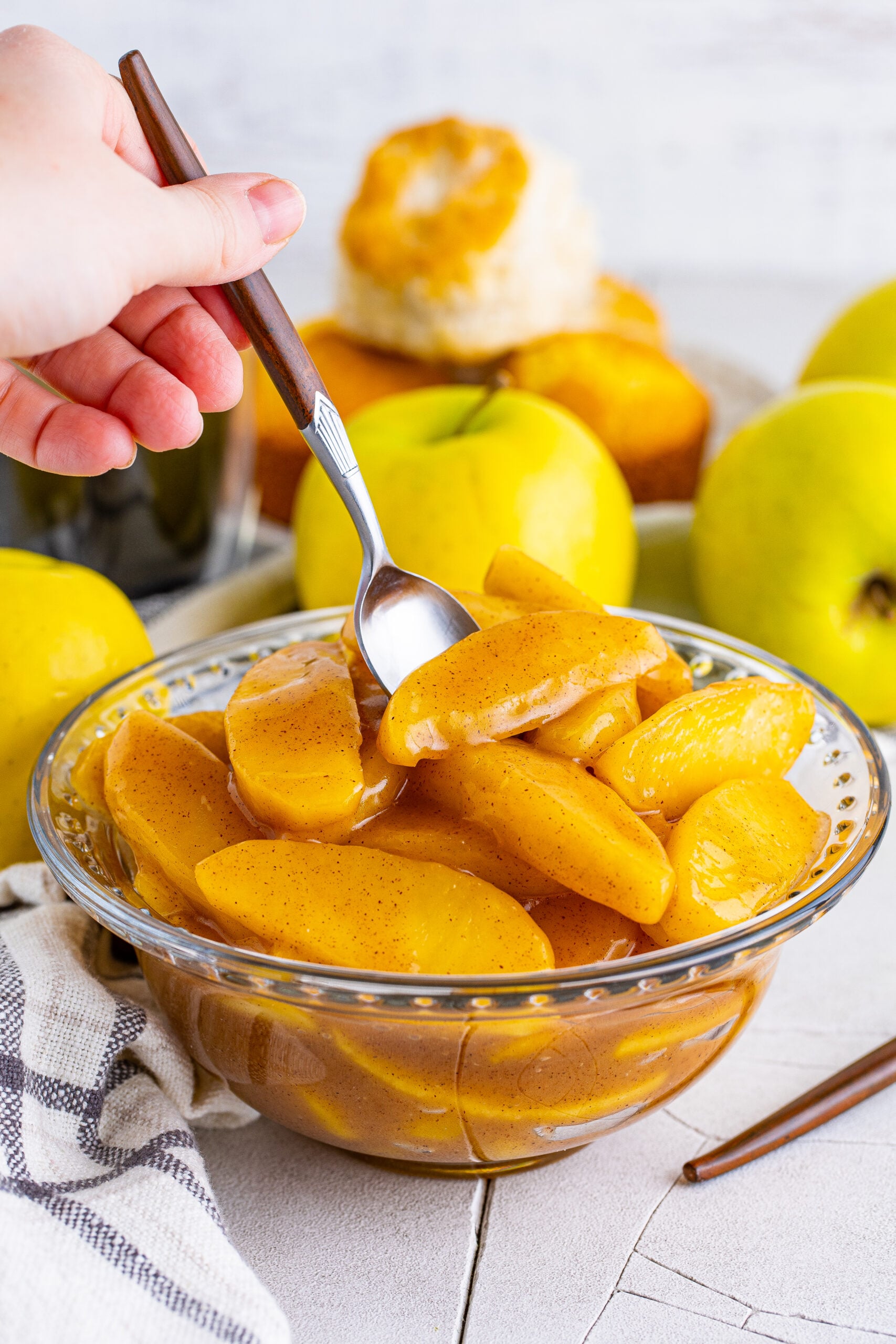 Front view of Cracker Barrel Fried Apples in a clear glass bowl with a silver spoon.