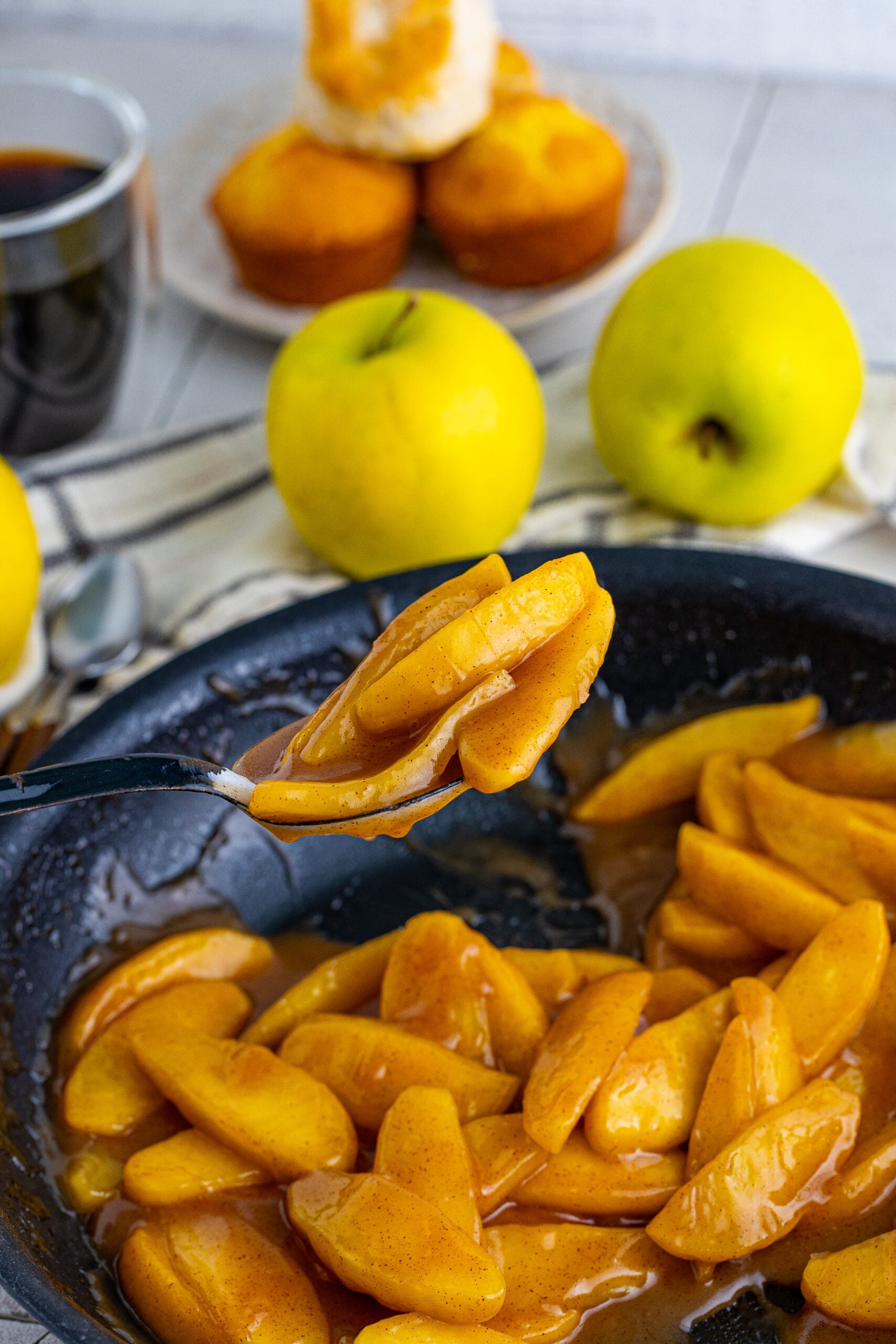Overhead view of a black spoon with a spoonful of Cracker Barrel Fried Apples.