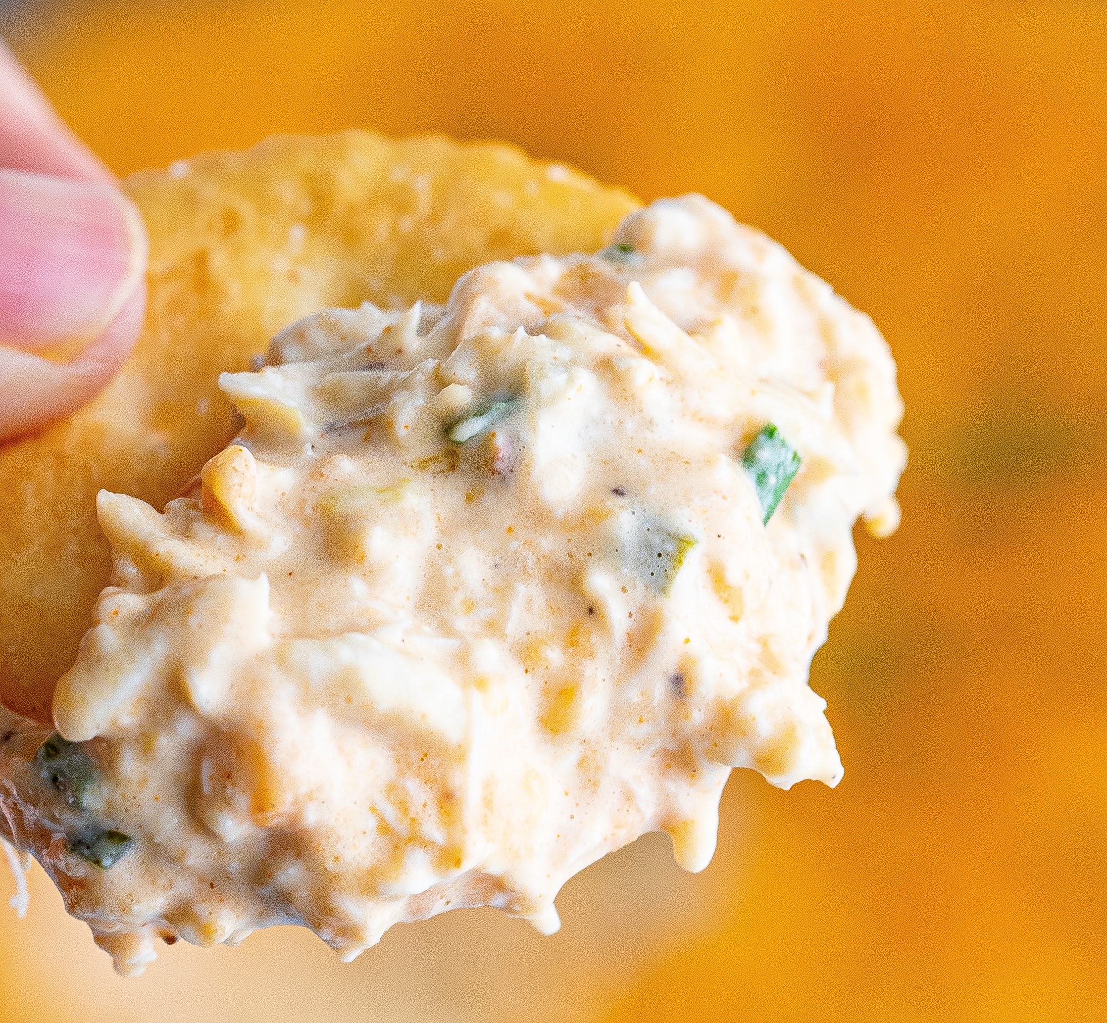 crab dip on a cracker being held up