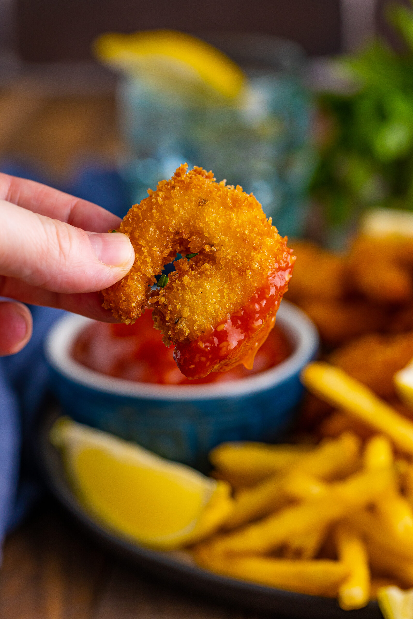 Close up view of Panko Fried Shrimp with the tip covered in cocktail sauce.