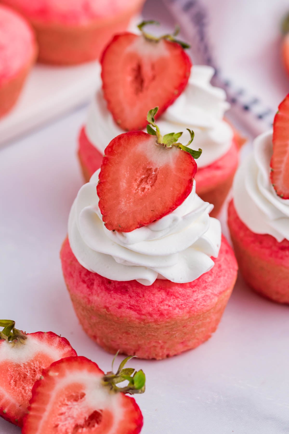 Front view of a Weight Watchers Strawberry Muffins topped with whipped cream and strawberry half.
