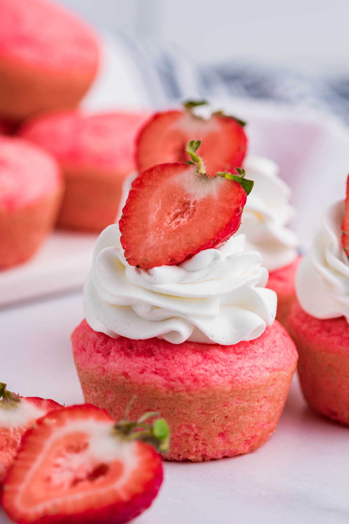 Front view of Weight Watchers Strawberry Muffins topped with whipped cream and a strawberry half.