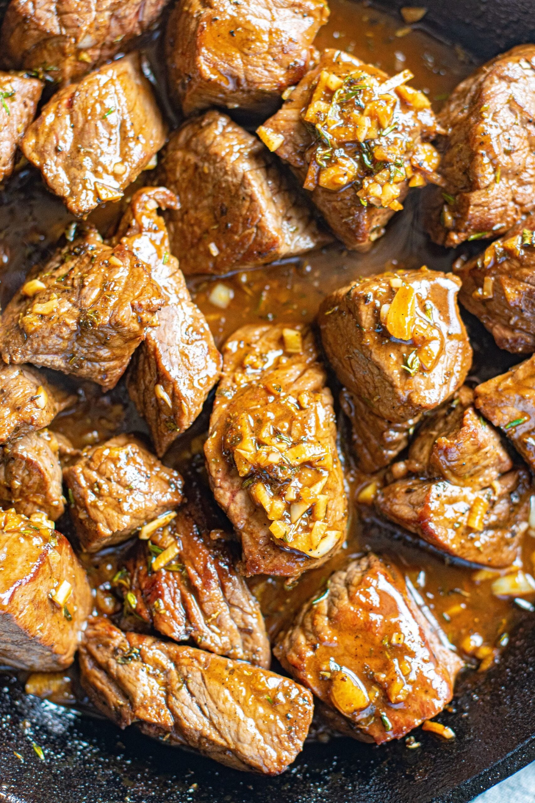 Up close view of Garlic Honey Steak Bites in a cast iron skillet.